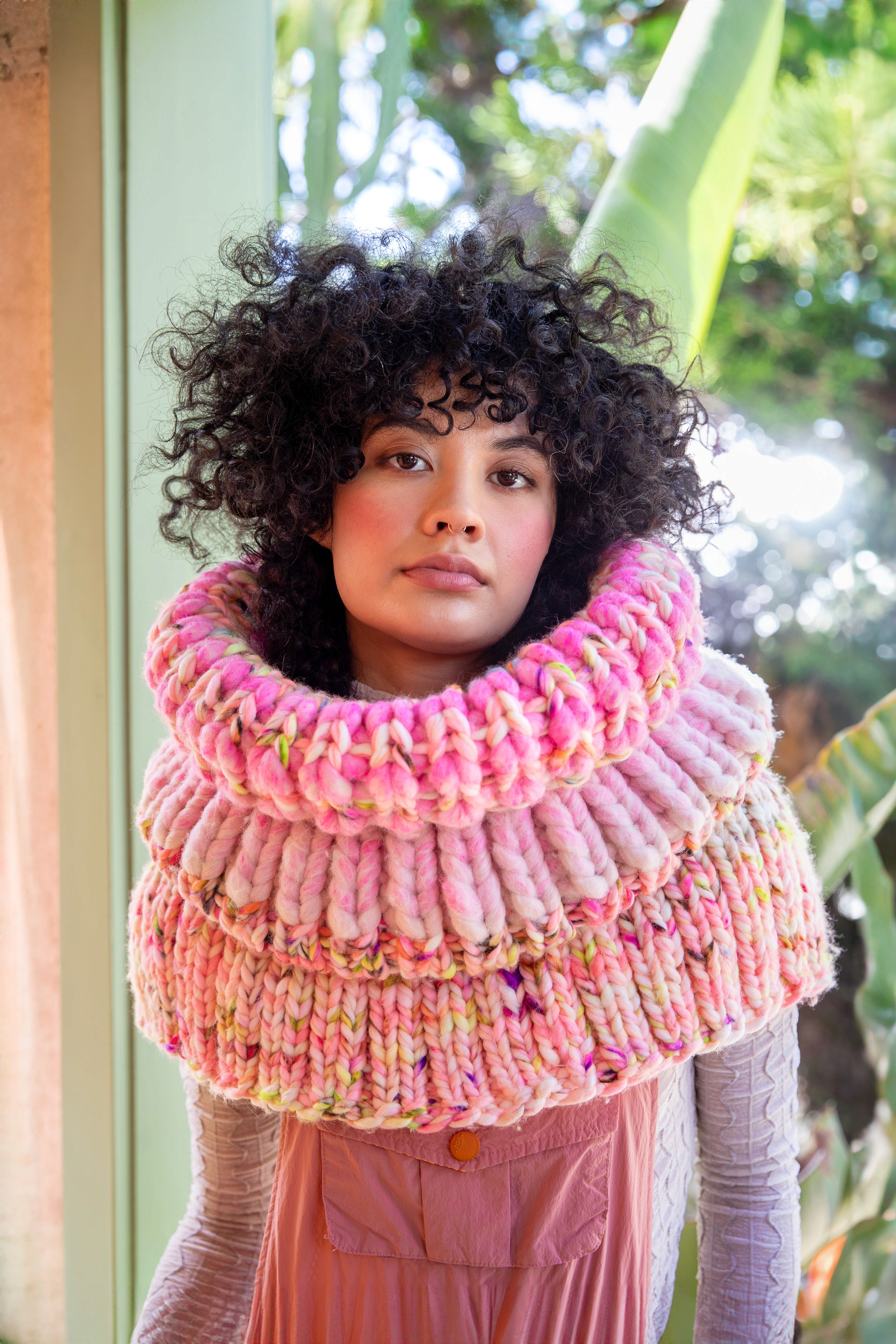 Stylish high-top sneakers featuring a combination of brown, cream, and navy blue leather details, worn with dark rolled-up jeans on a rustic wooden floor.