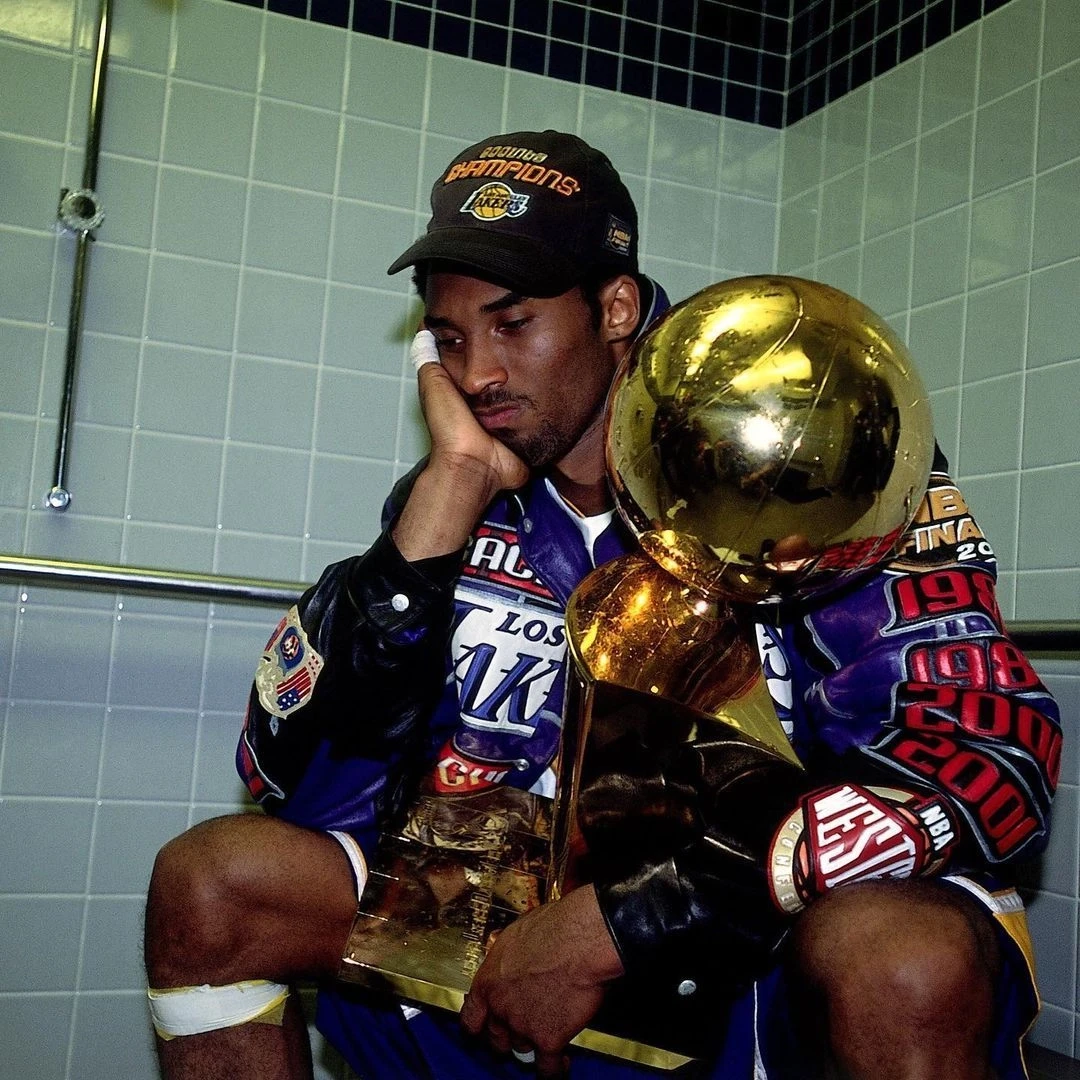 Candid 2001 photograph of Kobe Bryant sitting alone with the Larry O'Brien Championship Trophy, reflecting on the Lakers' NBA Finals victory.