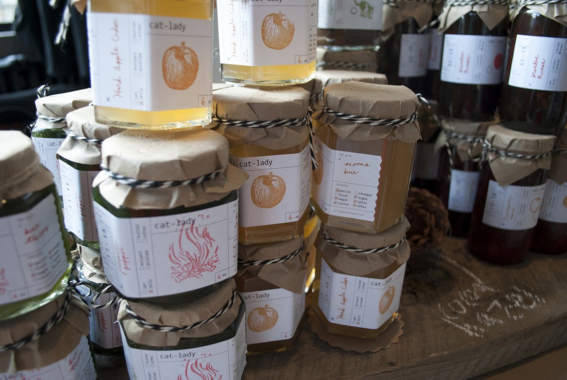 A photo with some jars that have different design labels on them.