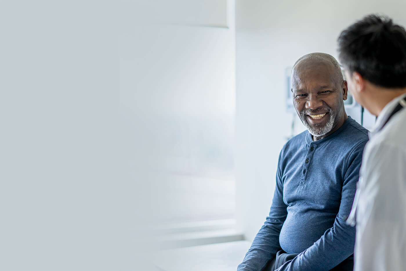 male patient with male doctor smiling
