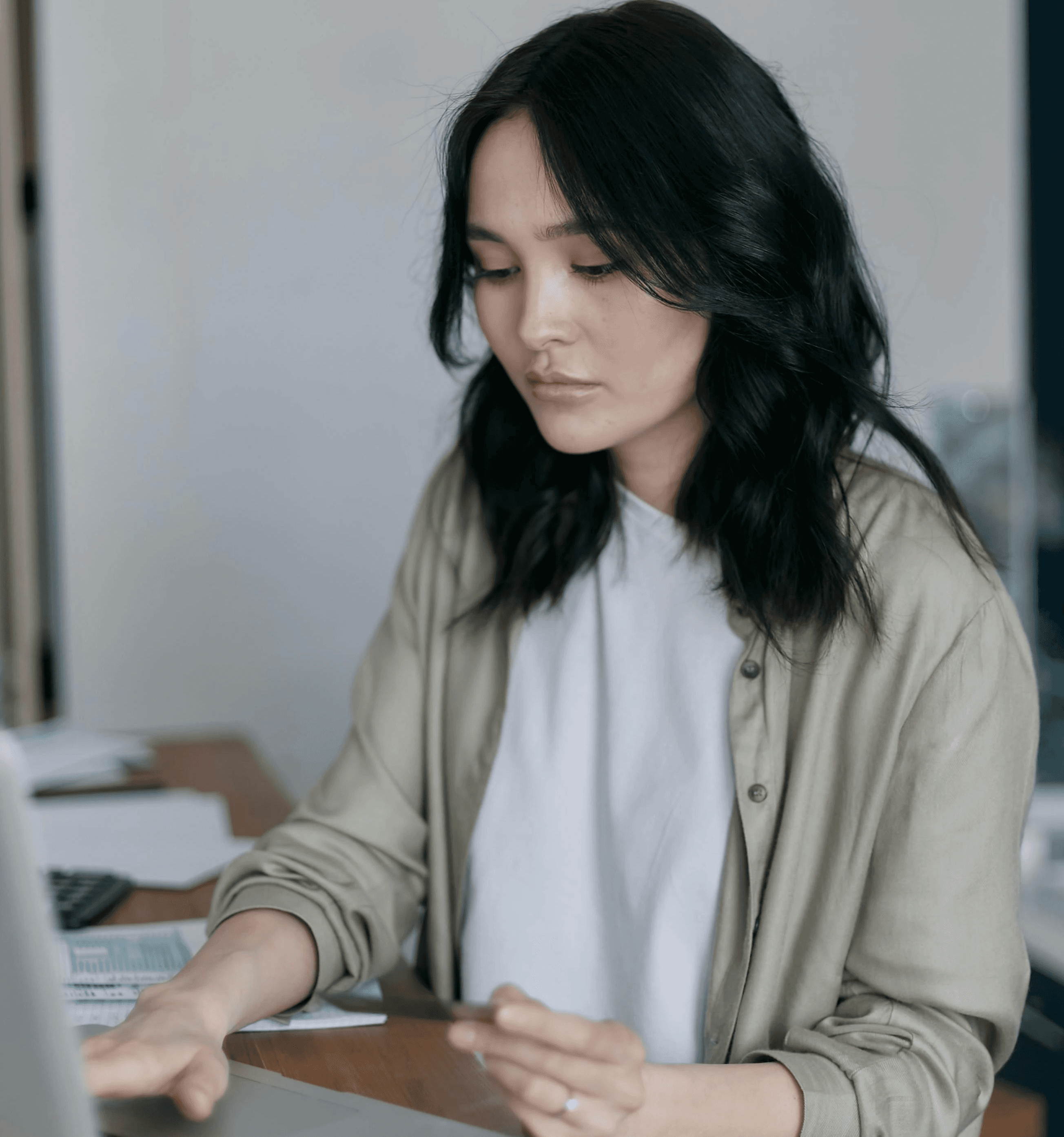 Giovane donna che studia online prendendo appunti al computer, con una tazza azzurra sul tavolo, simbolo di concentrazione e apprendimento personale.