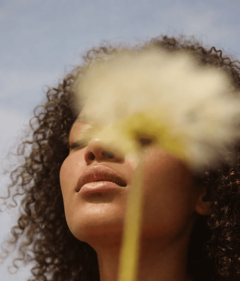 A person holding a tray filled with golden-brown, crispy snacks or appetizers in a kitchen setting.