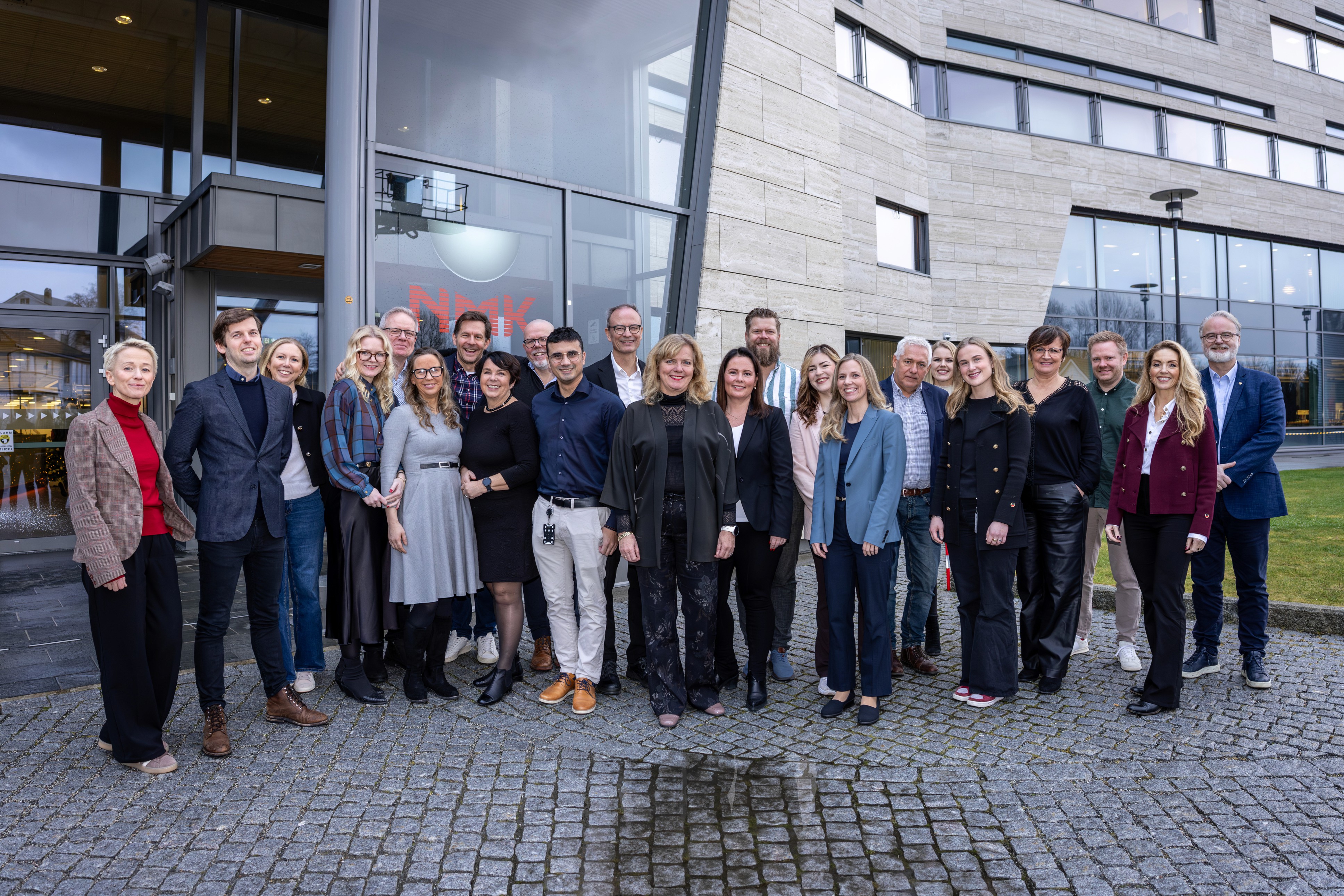 Four business professionals engaging in a handshake during a meeting at a modern office setting.