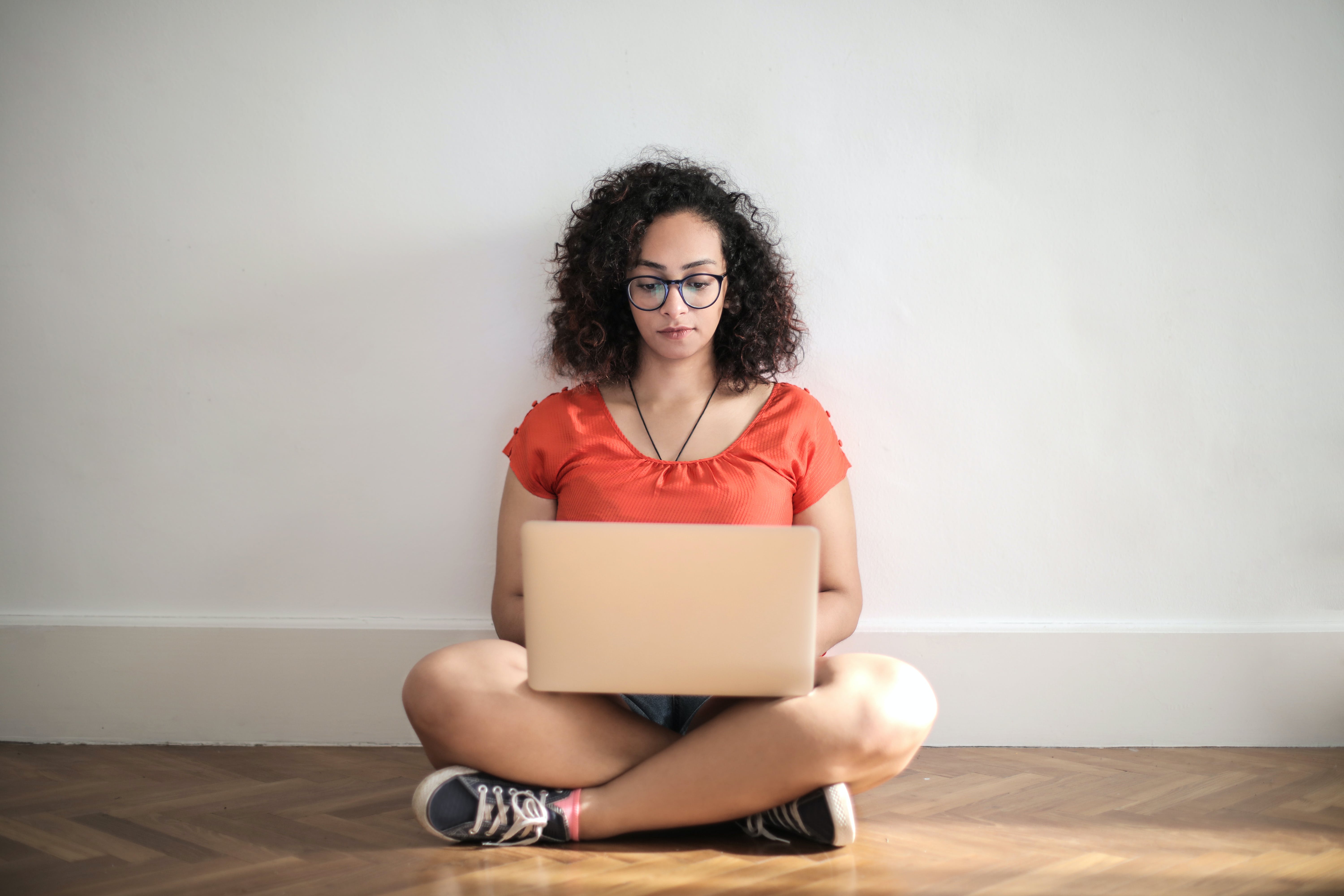 Woman sitting on a brown wooden floor mastering sales canvassing