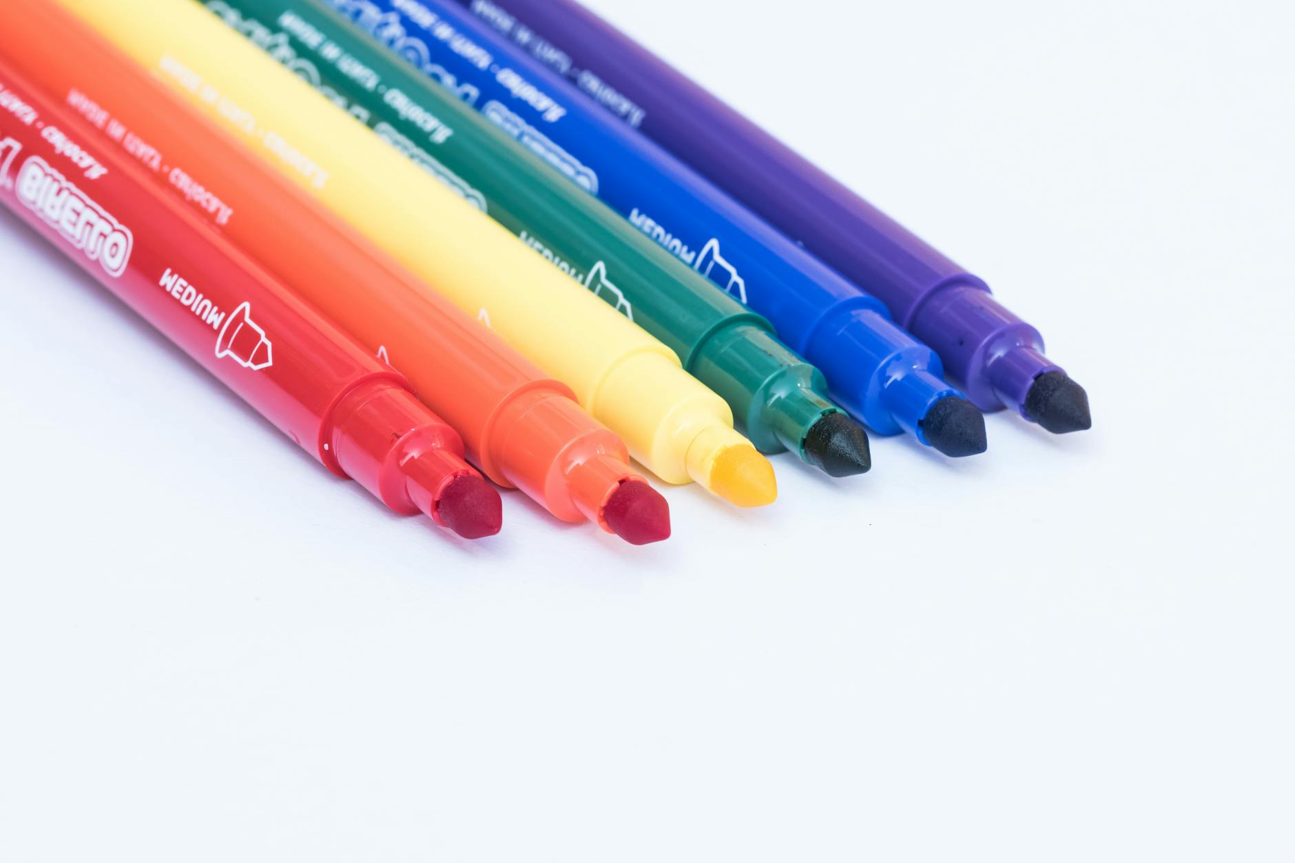 A set of first 100 words flash cards and a colorful workbook spread out on a child-sized wooden table.