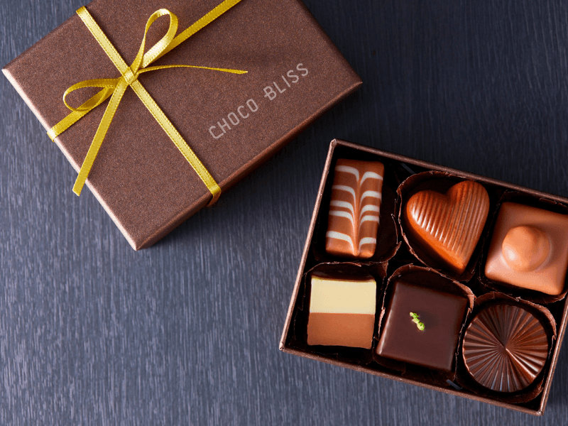 A chocolate truffle with a brand logo