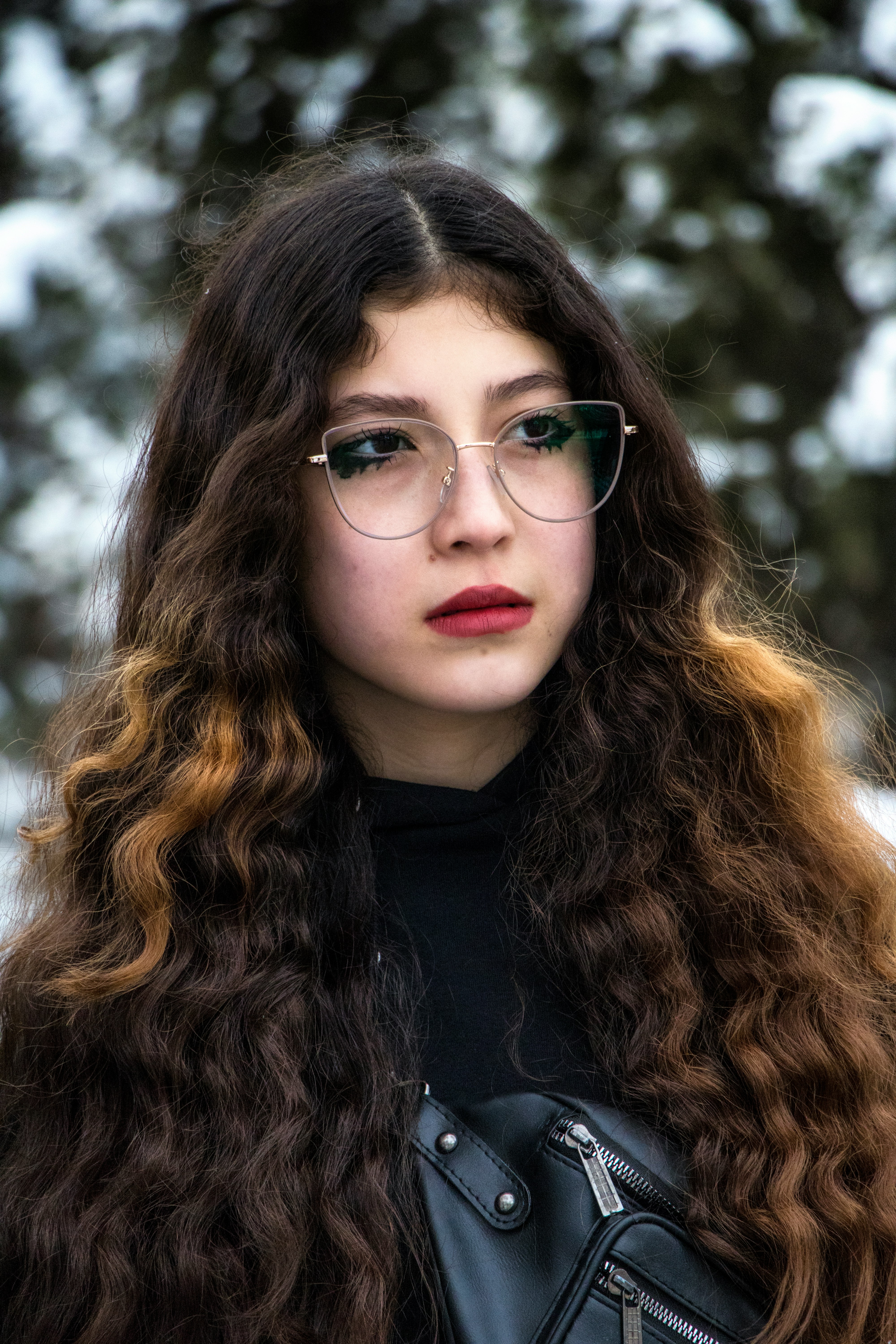 a woman with long curly hair wearing glasses