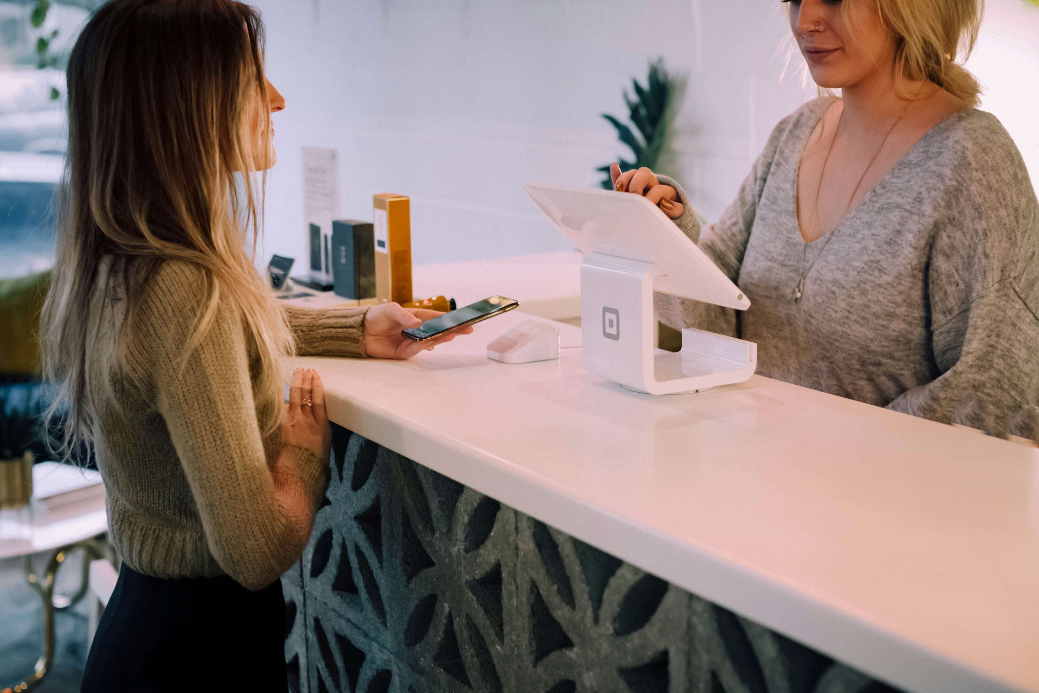 a customer paying for a purchase in a store with a lady cashier