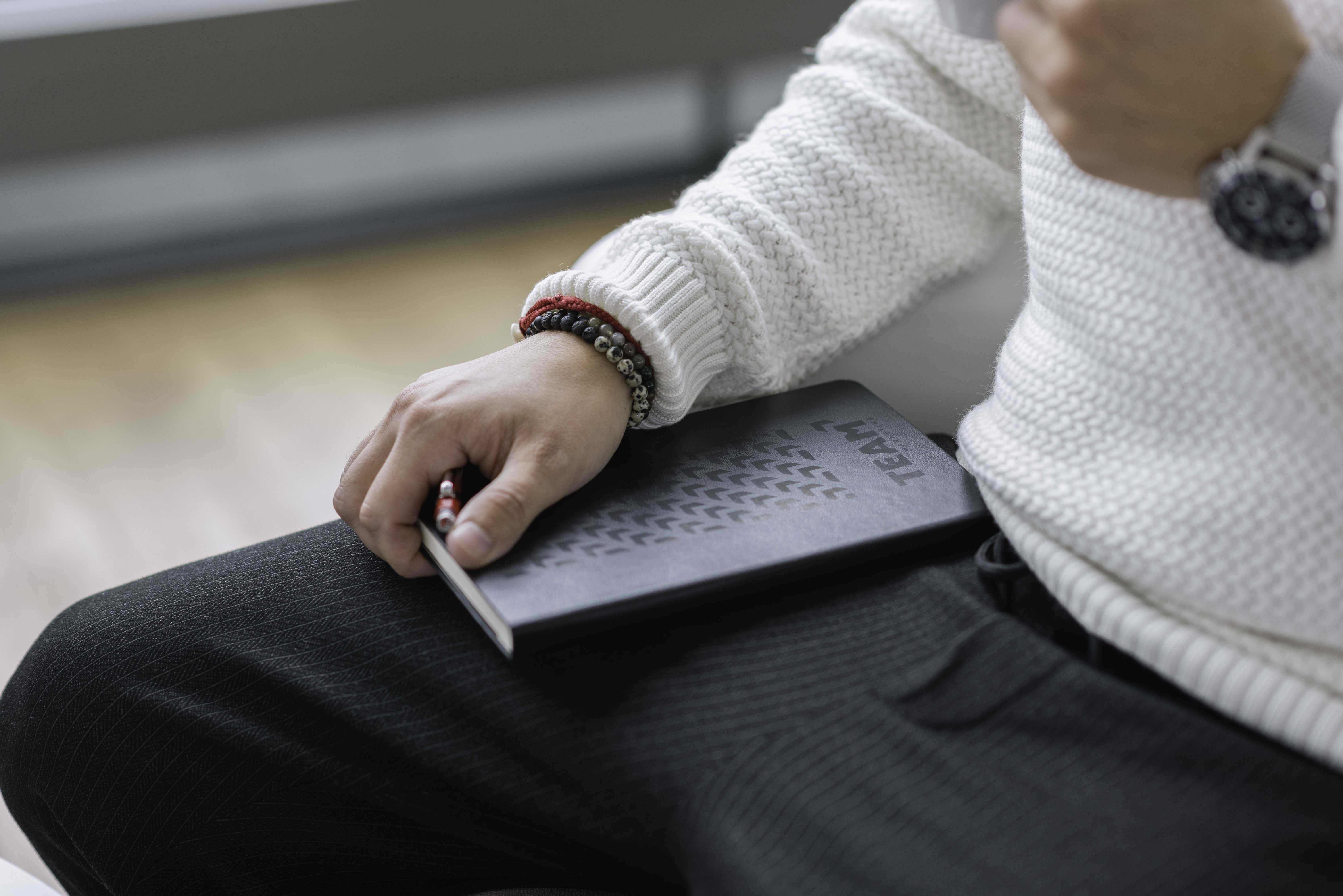 Close-up of a person holding a Team-branded notebook, showcasing the company’s professional merchandise.