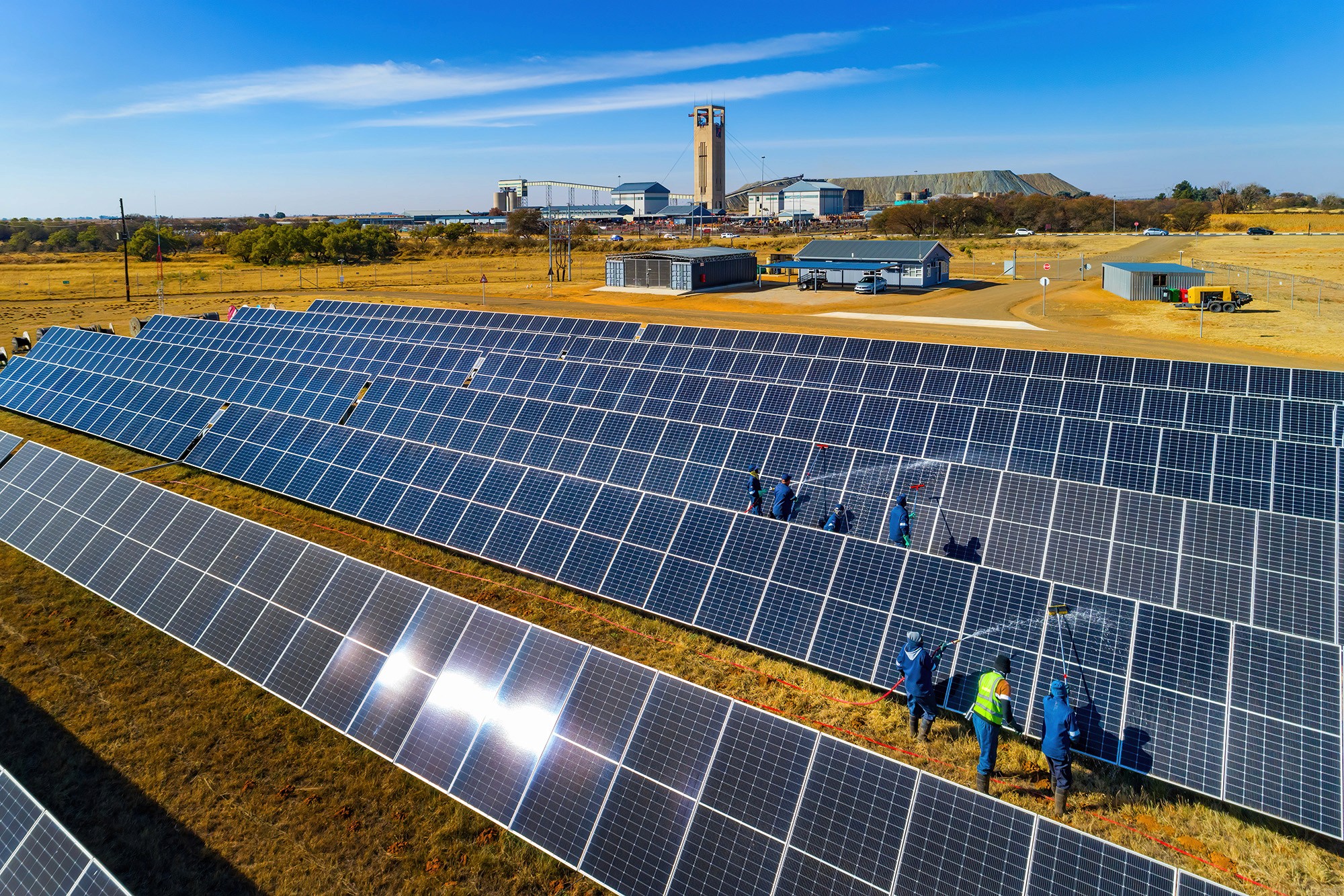Solar energy workers installing panels at an African industrial site