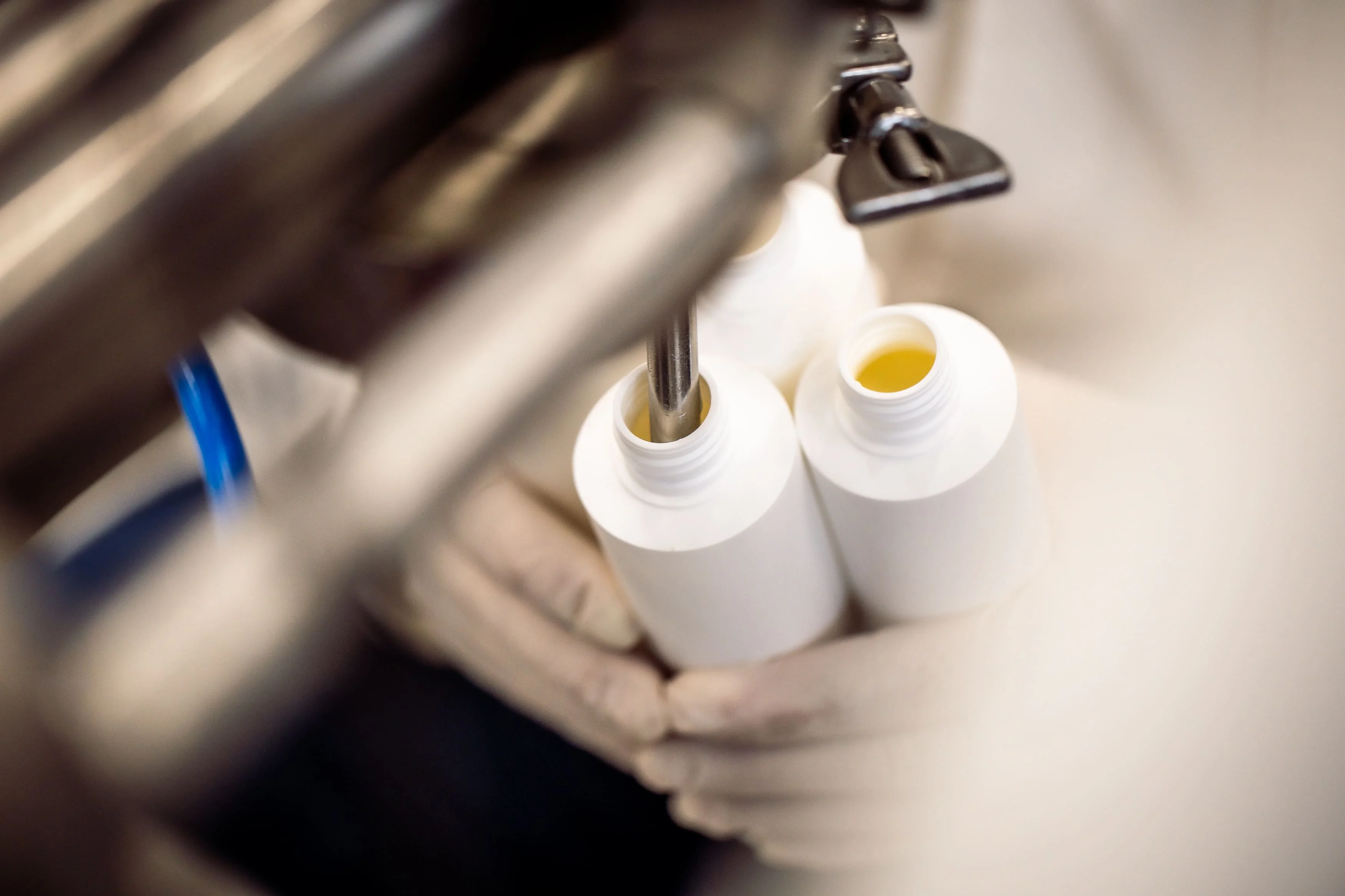 Remplissage des flacons du Baume Intégral dans notre laboratoire en Provence, fabrication artisanale de soins naturels et bio.