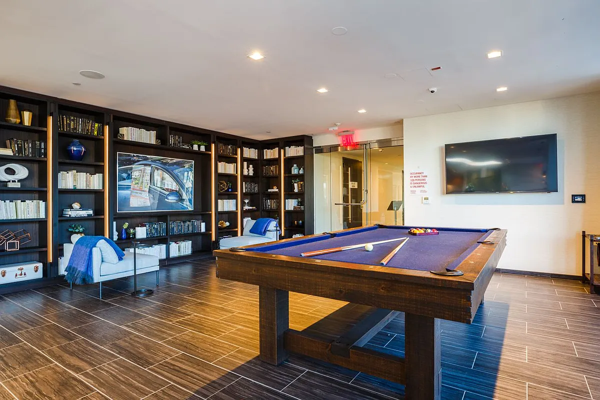 A billiard table and a pool table are set up in a spacious game room, ready for play and entertainment.
