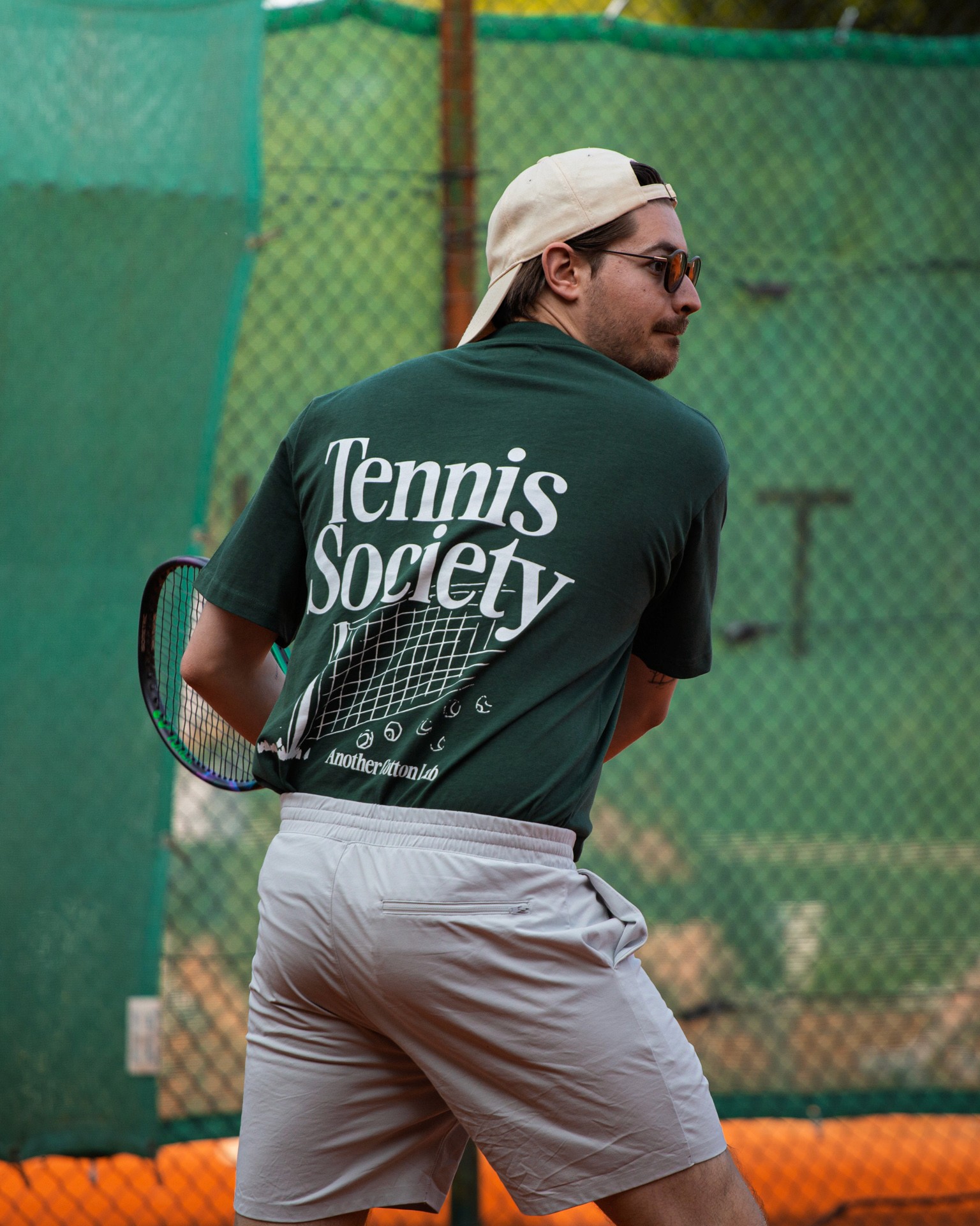 Tennismeisterei Tennistraining: Ein Tennisspieler mit Sonnenbrille vor dem Schlag