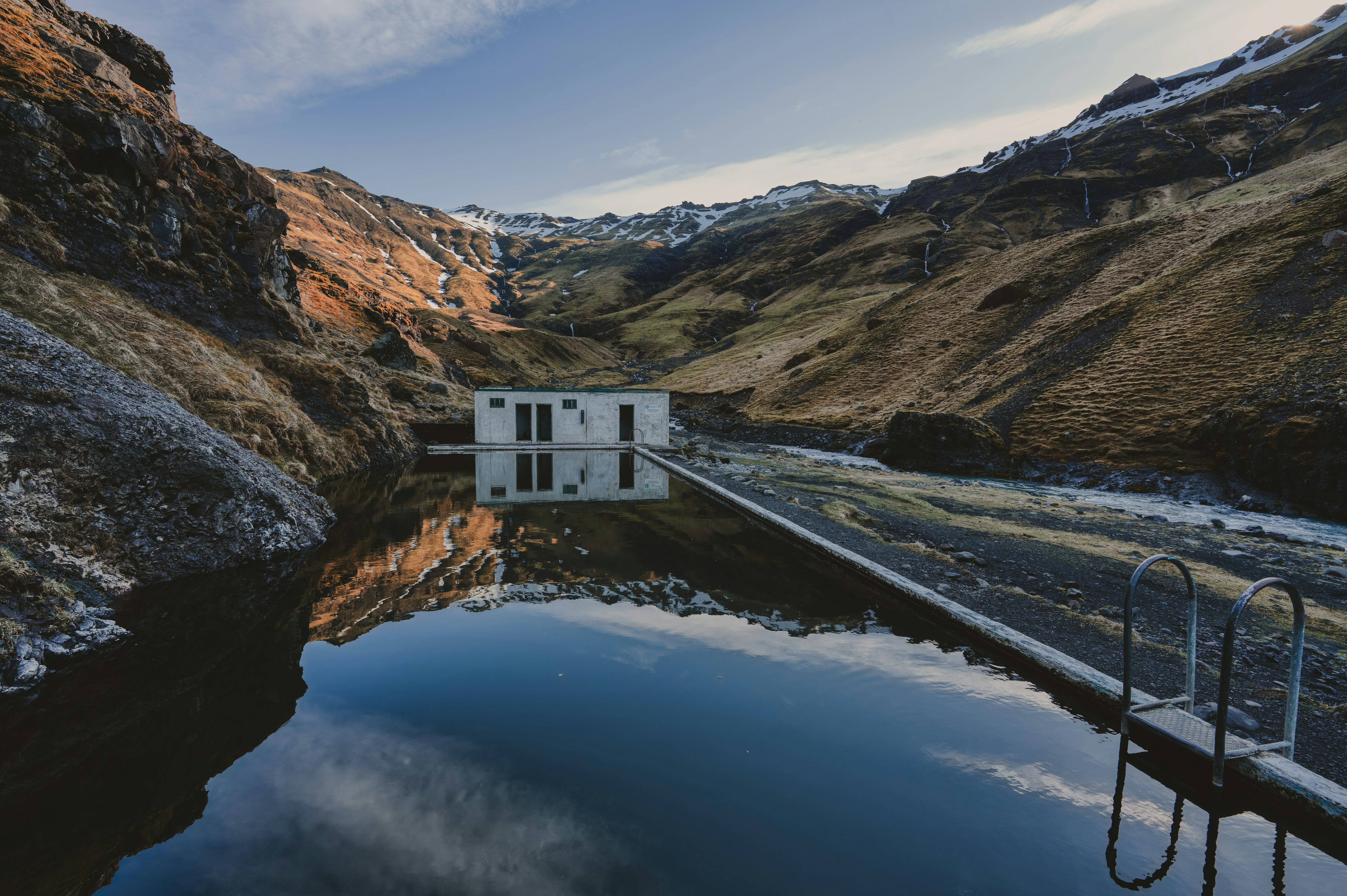 Seljavallalaug outdoor swimming pool surrounded by mountains in South Iceland.