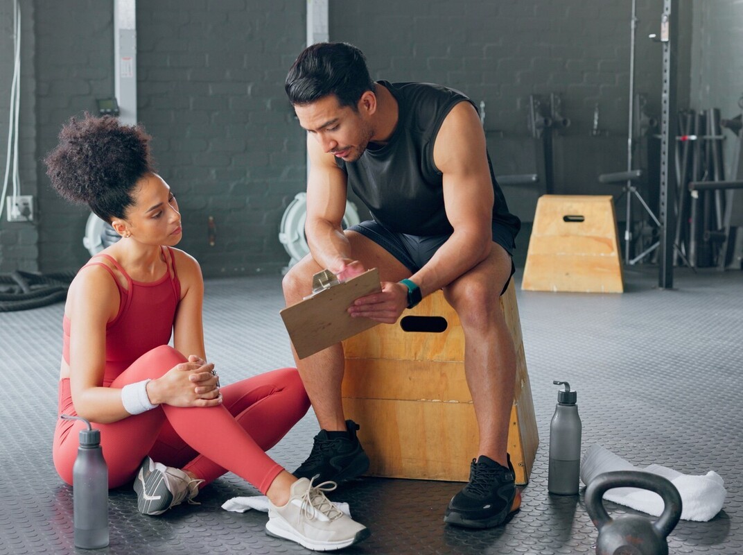 woman working withher fitness instructor to decide if she needs more than 10k steps a day weight loss