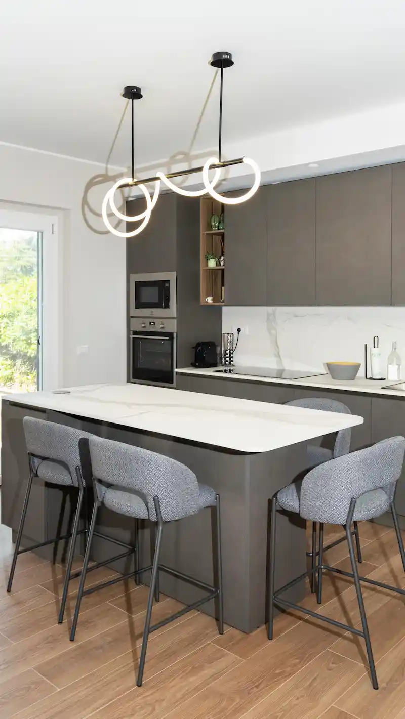 cucina con parquet e isola moderna con lampada sospesa di design