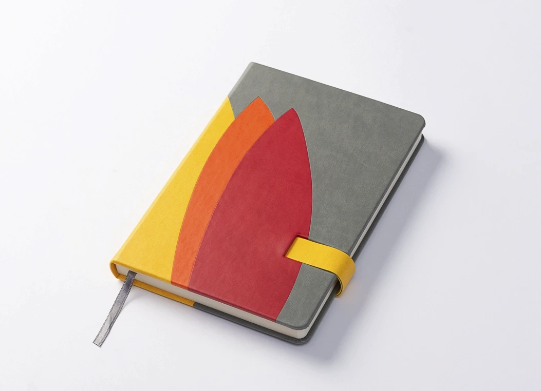 Angled view of color block journal with strap and ribbon bookmark