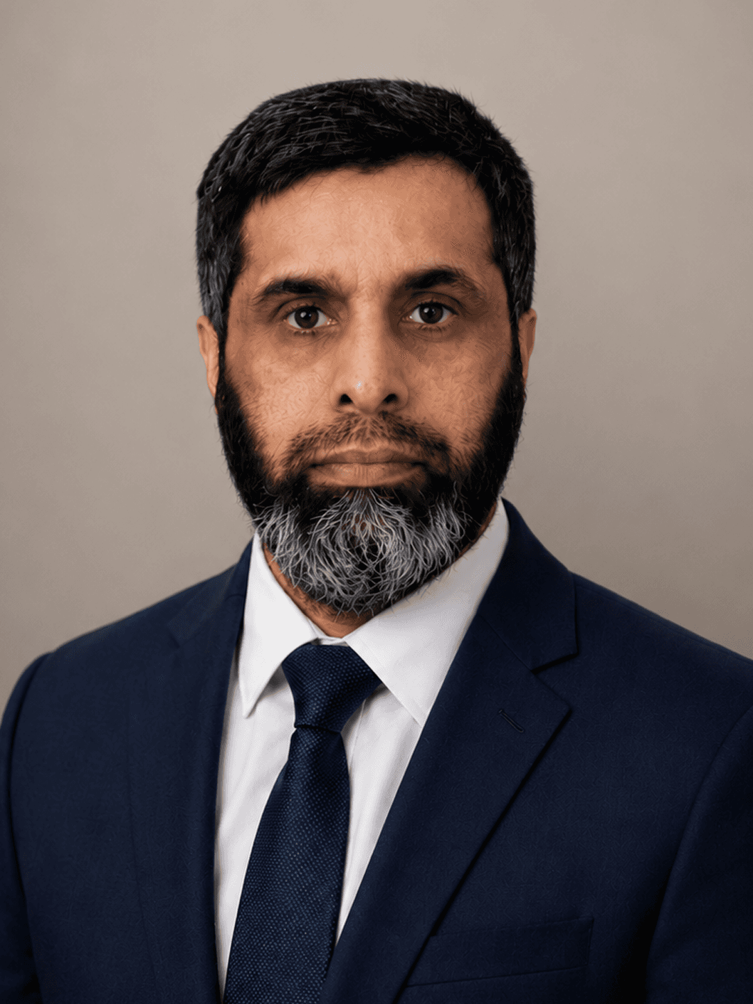 Abdul Kapadia in a blue suite against a neutral background