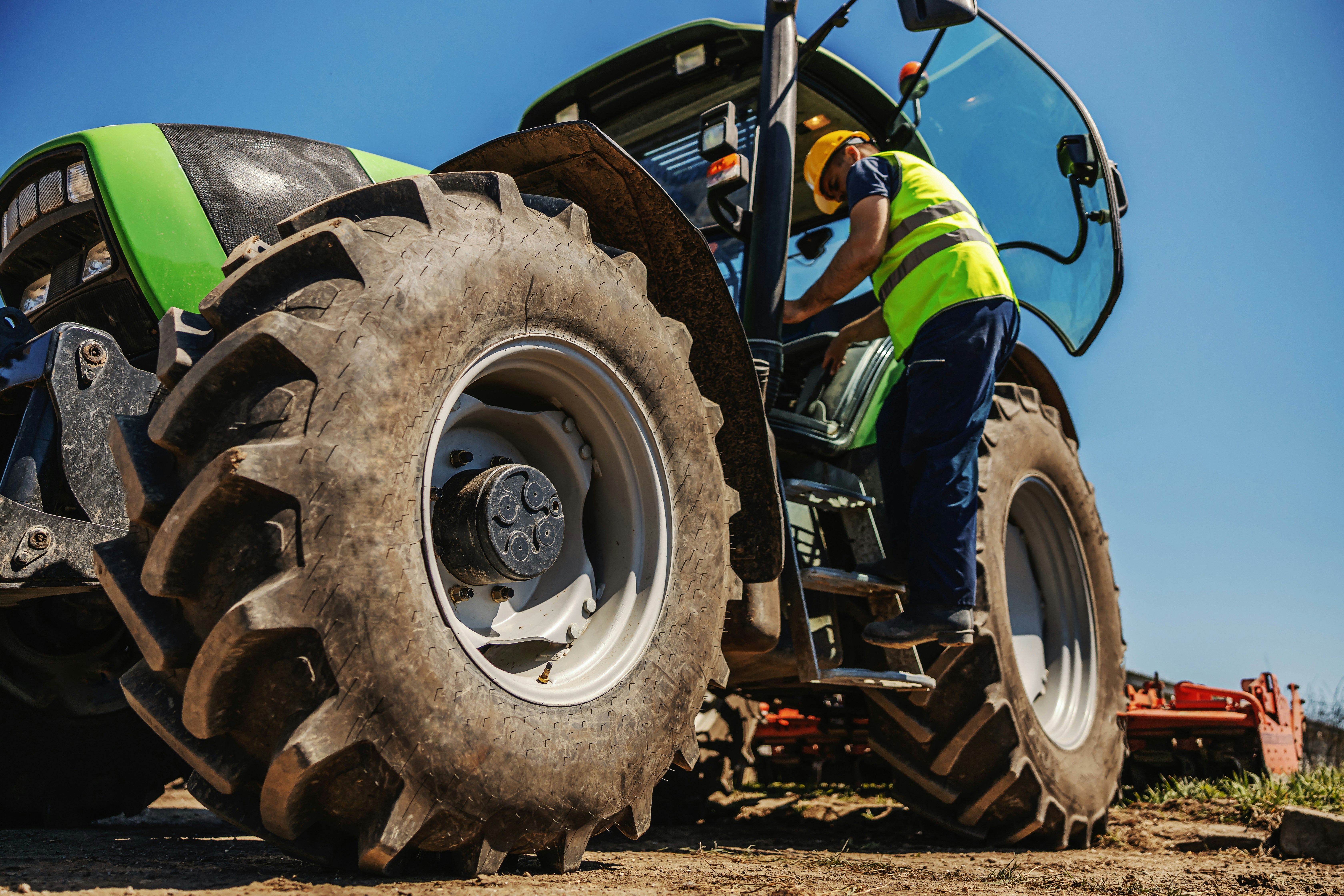 Farmer stepping down from cab of large tractor