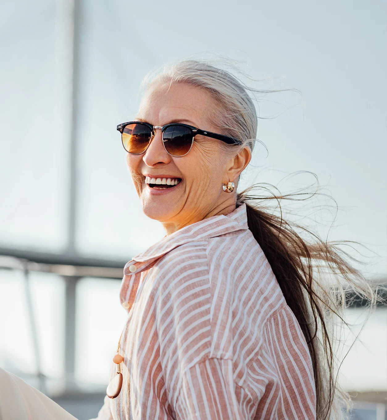 Smiling older woman outdoors representing renewed confidence and improved quality of life after treatment.