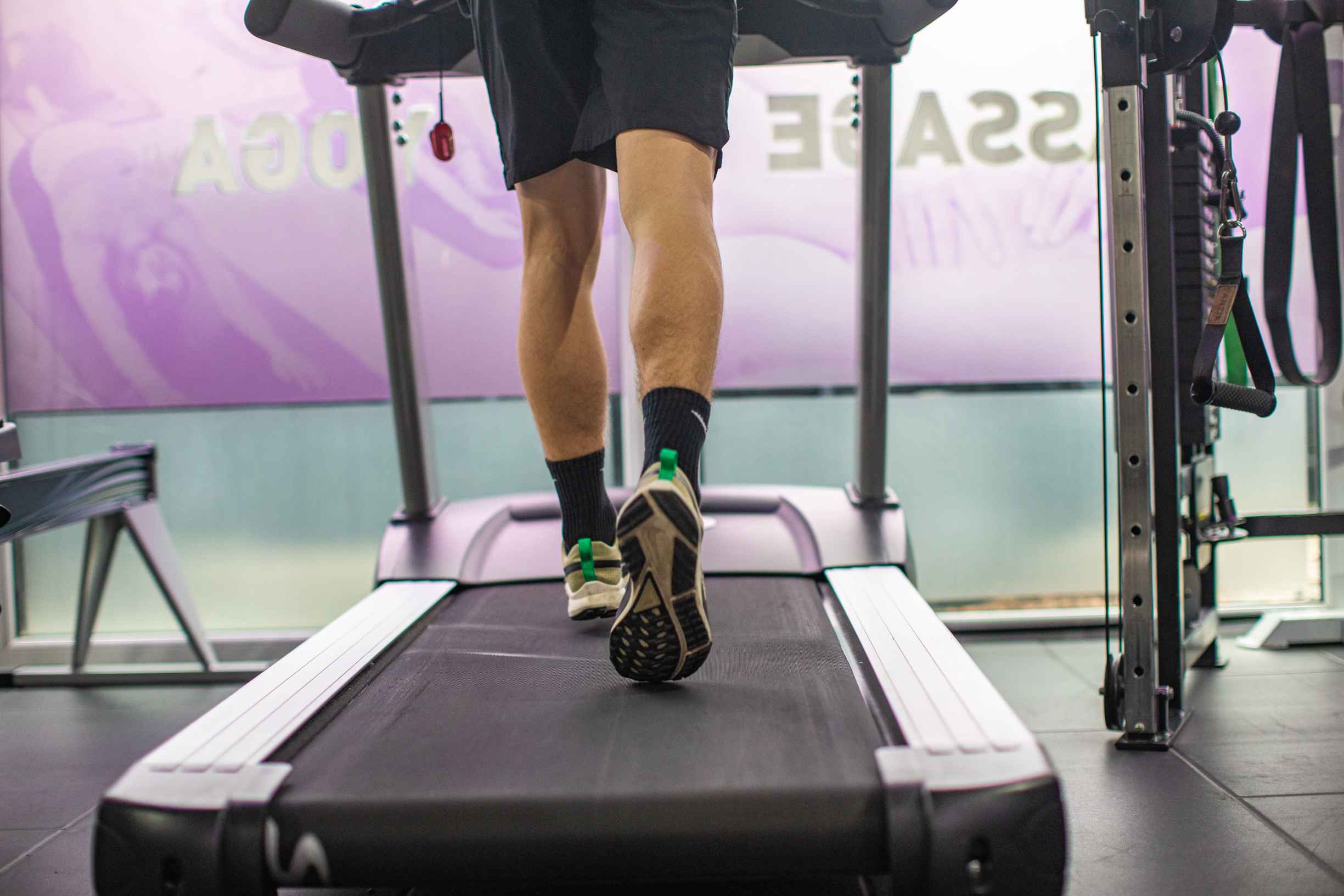 A person runs on a treadmill in a gym, showcasing determination for his smart fitness goals by Alchemy