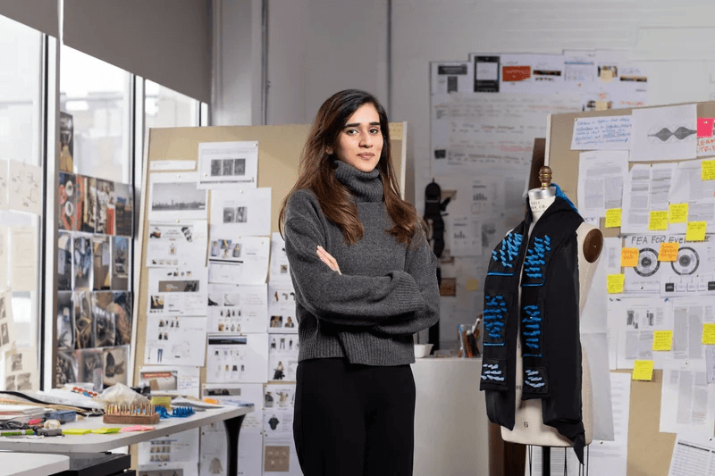 Design student Rabia Razzaq G’23 stands next to the prototype of a weighted sensory scarf that she is developing. She collaborated with InclusiveU student Andrew Dingel ’22 on the idea of creating a scarf that would help ease anxiety.