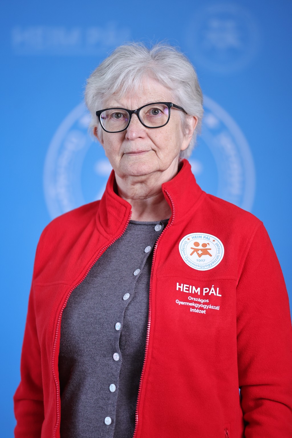 Ősz hajú nő piros kardigánban