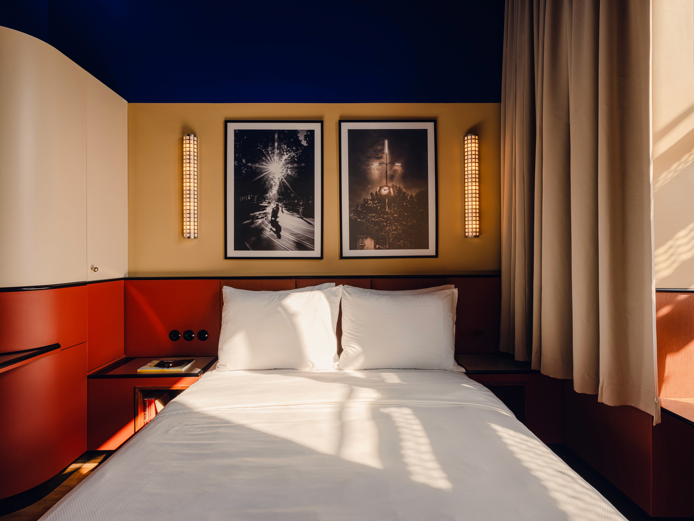 View of bed with cleanly organized pillows in The Companion Hotel