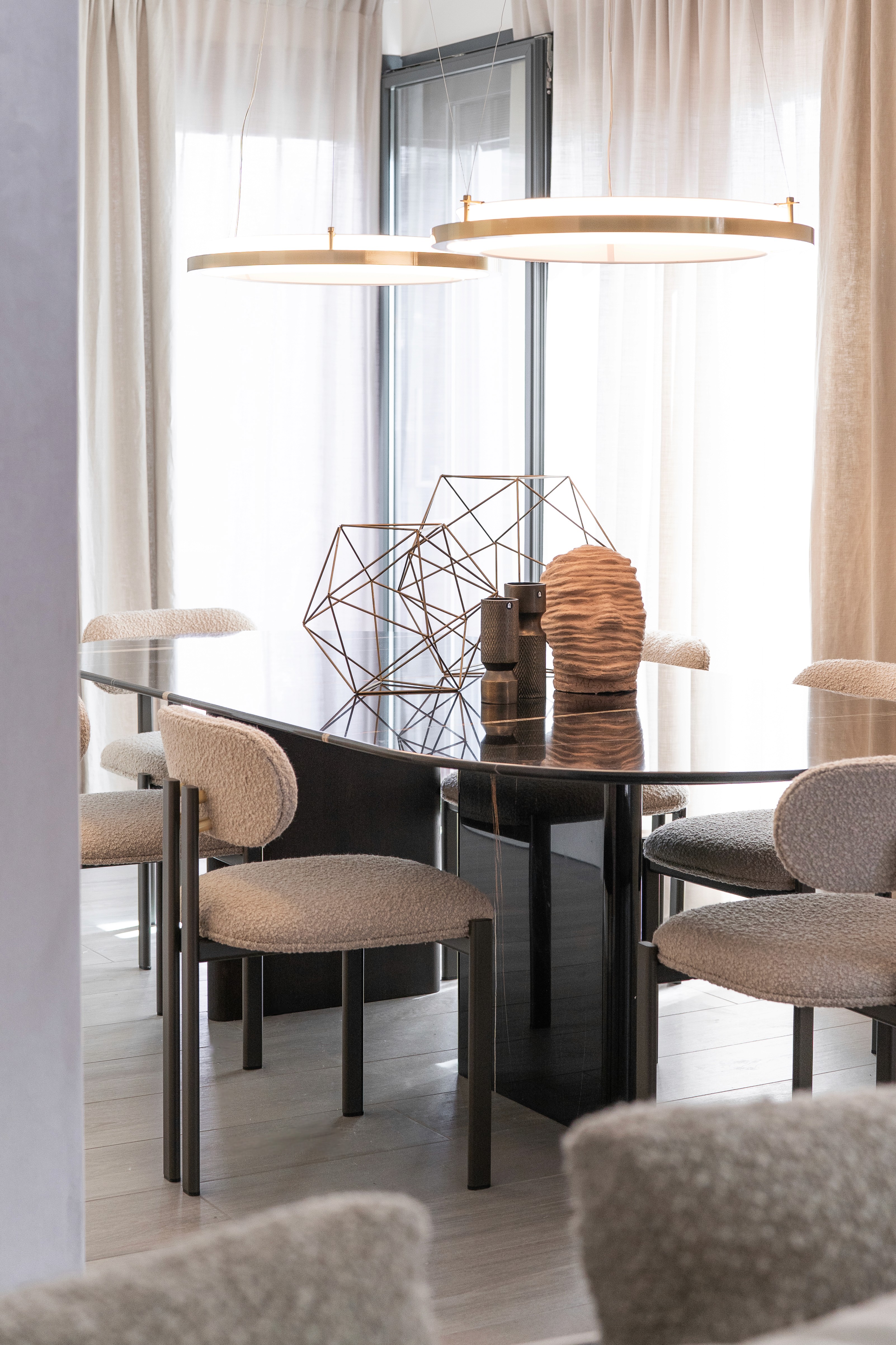 Zona de comedor con mesa de mármol oscuro y sillas de tela