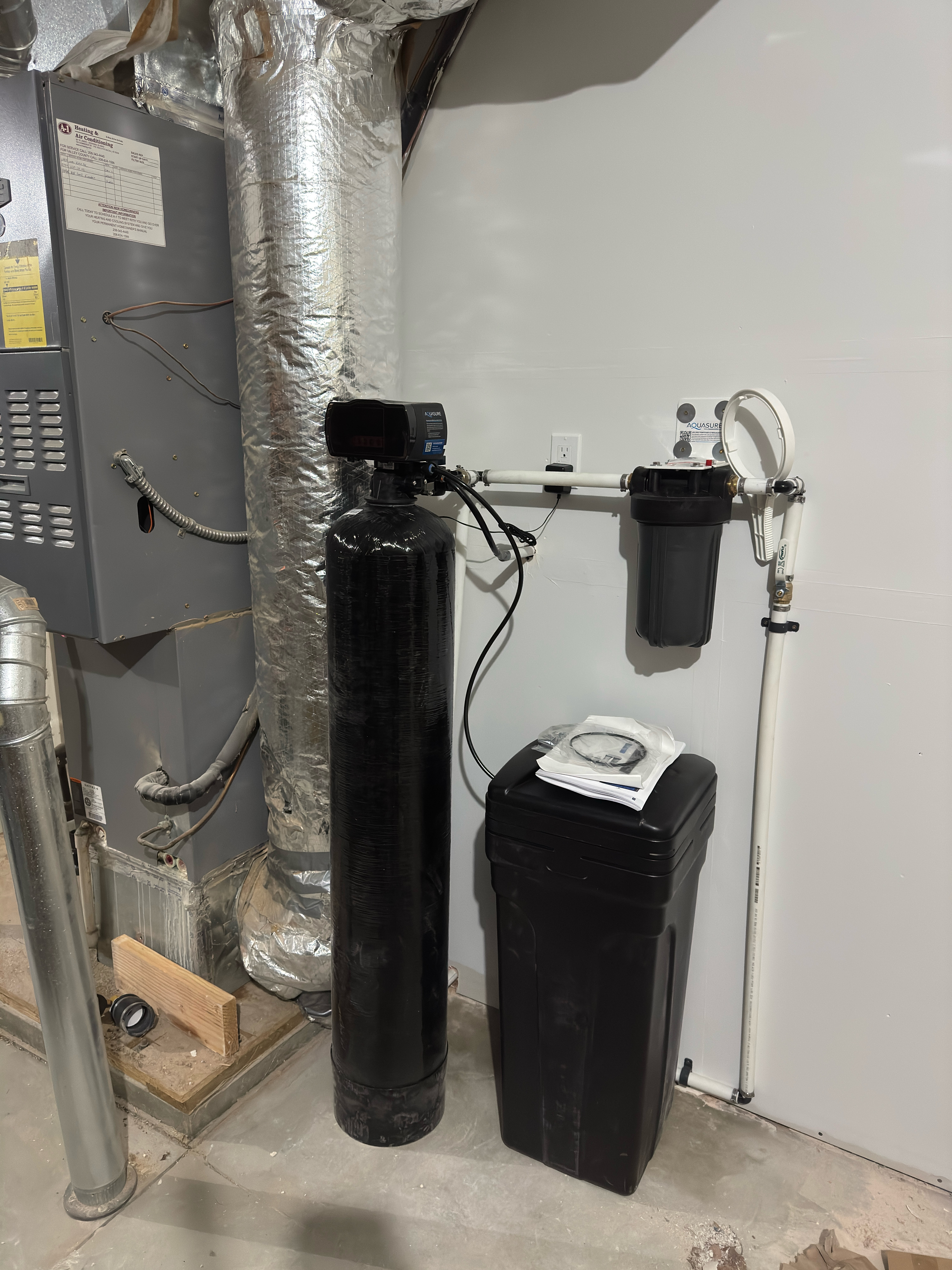 Smiling young man with short hair poses against a dark background, wearing a green button-up shirt.