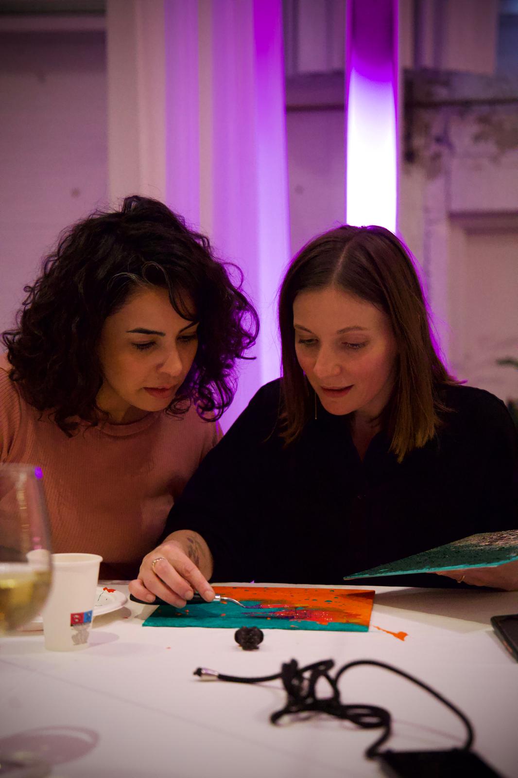 A winding road cuts through rocky terrain, surrounded by patches of green grass and illuminated by sunlight.
