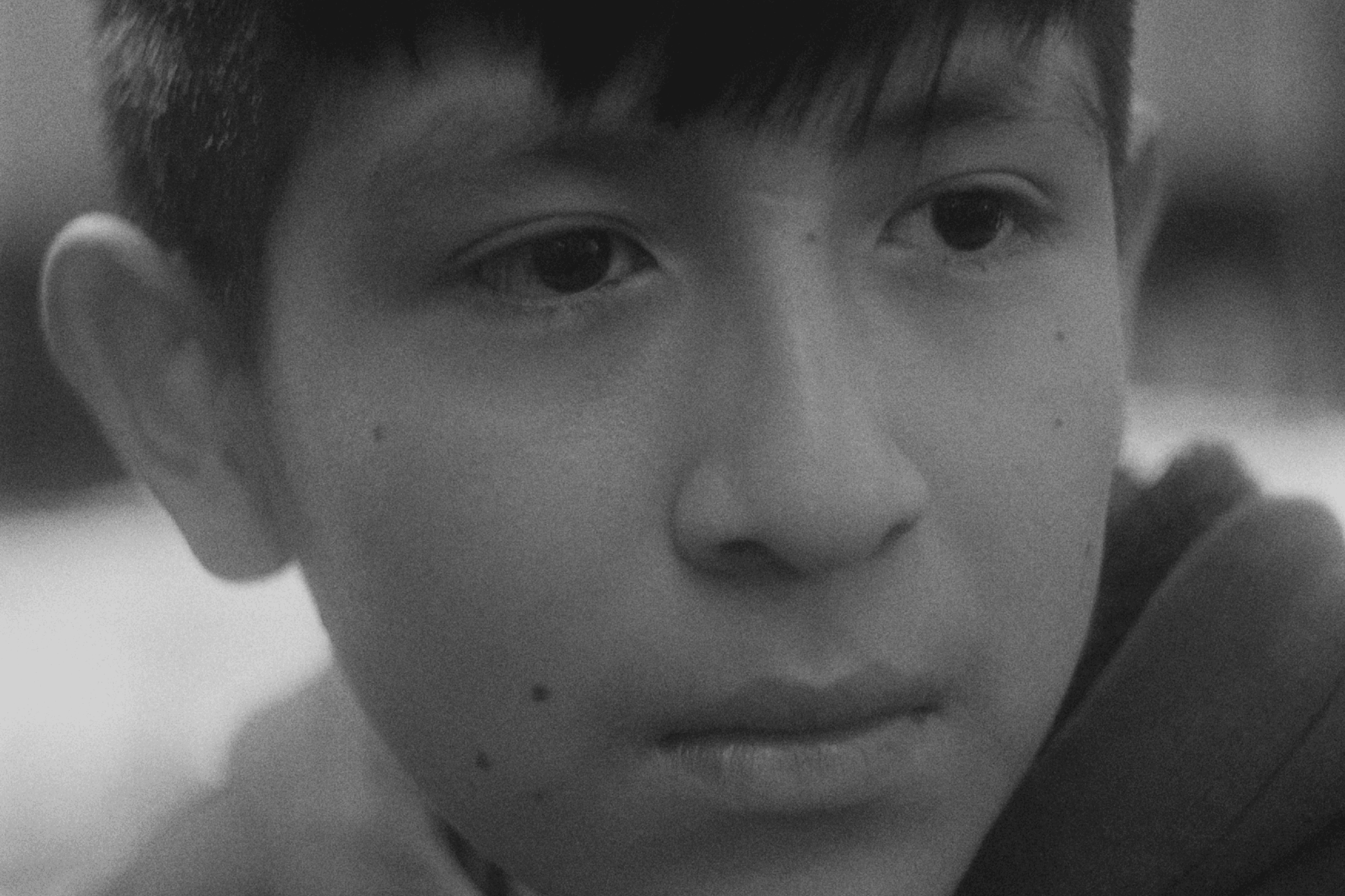 View of the French countryside through a stone villa’s open living room, with sofas and trees framing the scene