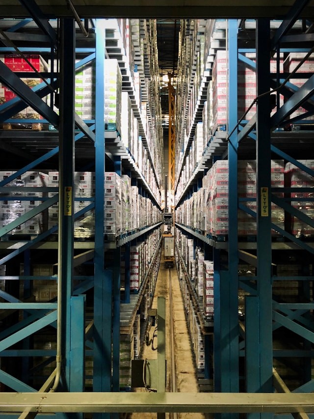 Tall storage racks filled with goods inside a large warehouse aisle.
