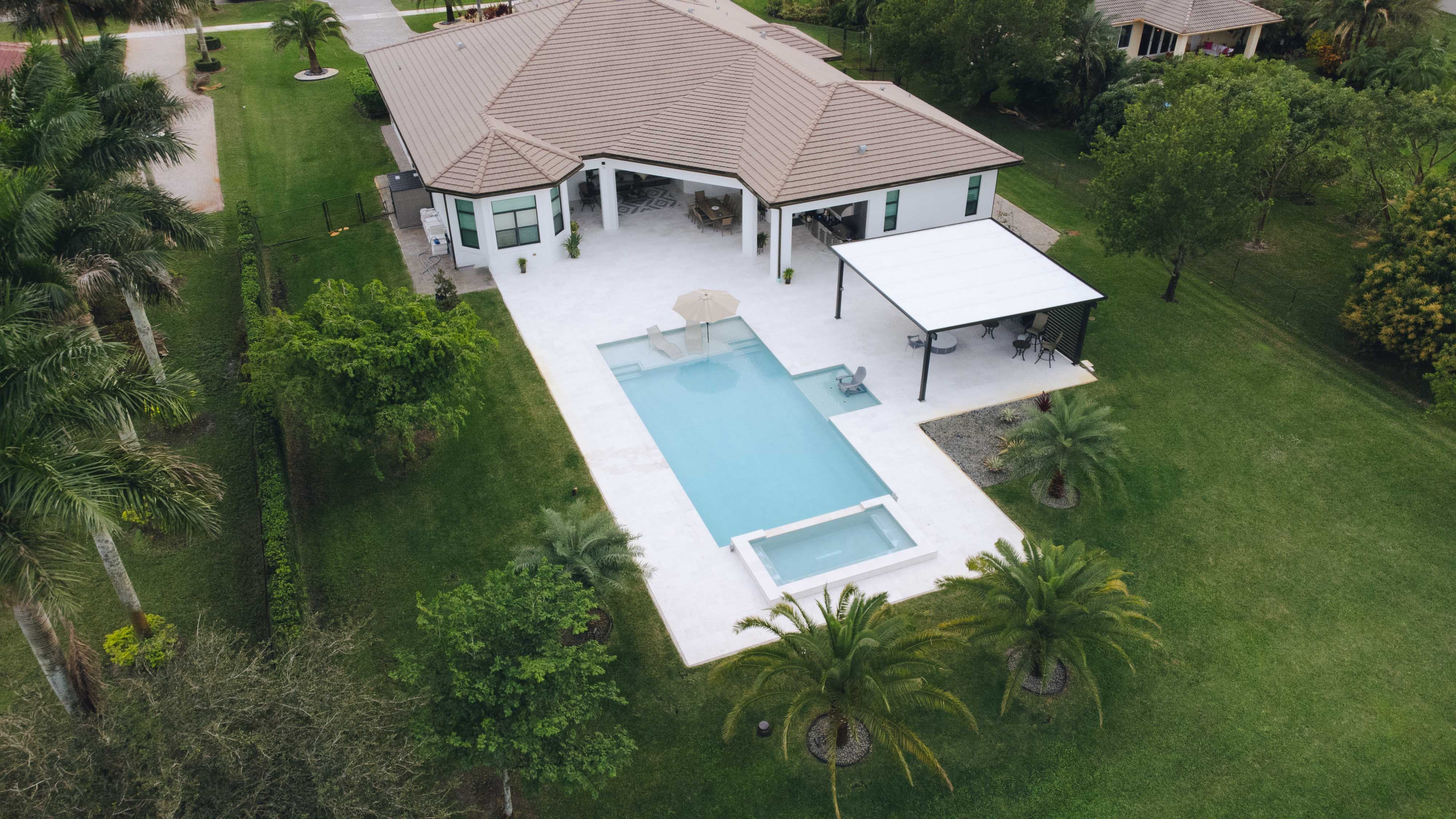 Aerial view of a luxury home with a swimming pool and spa