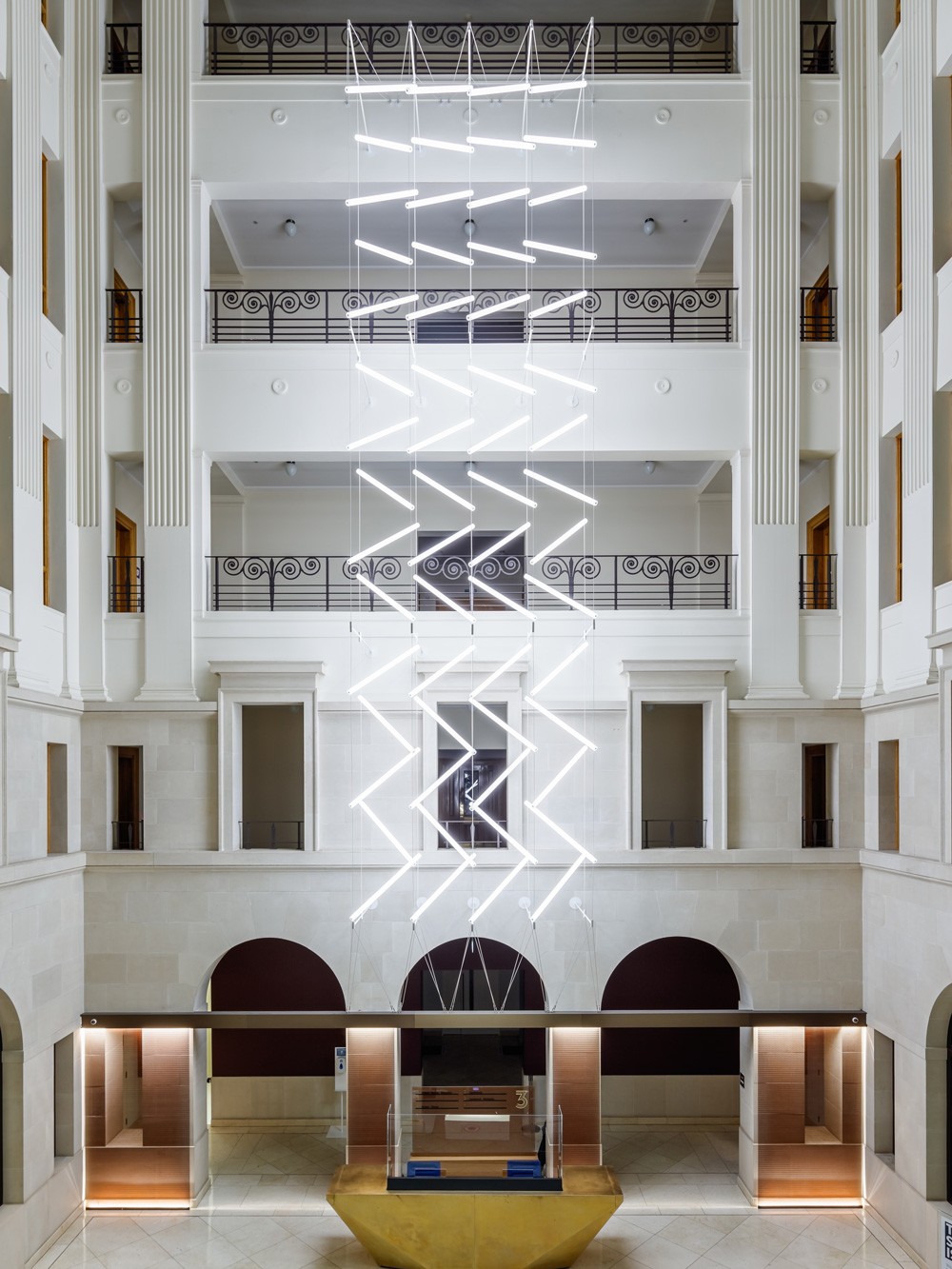 Suspended lighting installation in Brindley Place atrium featuring 60 custom acrylic LED units in a zig-zag formation
