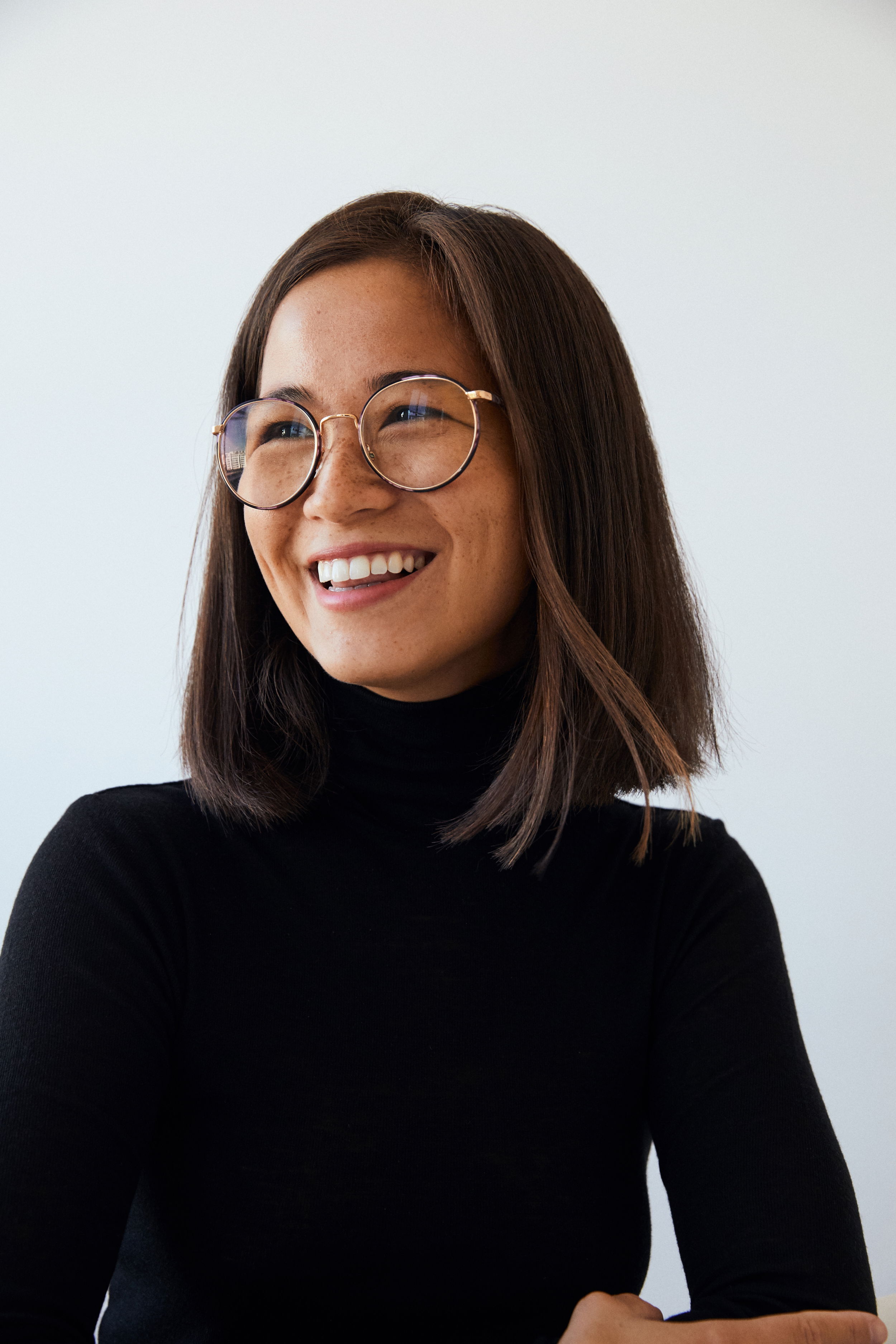 image of woman with glasses looking to the left and smiling