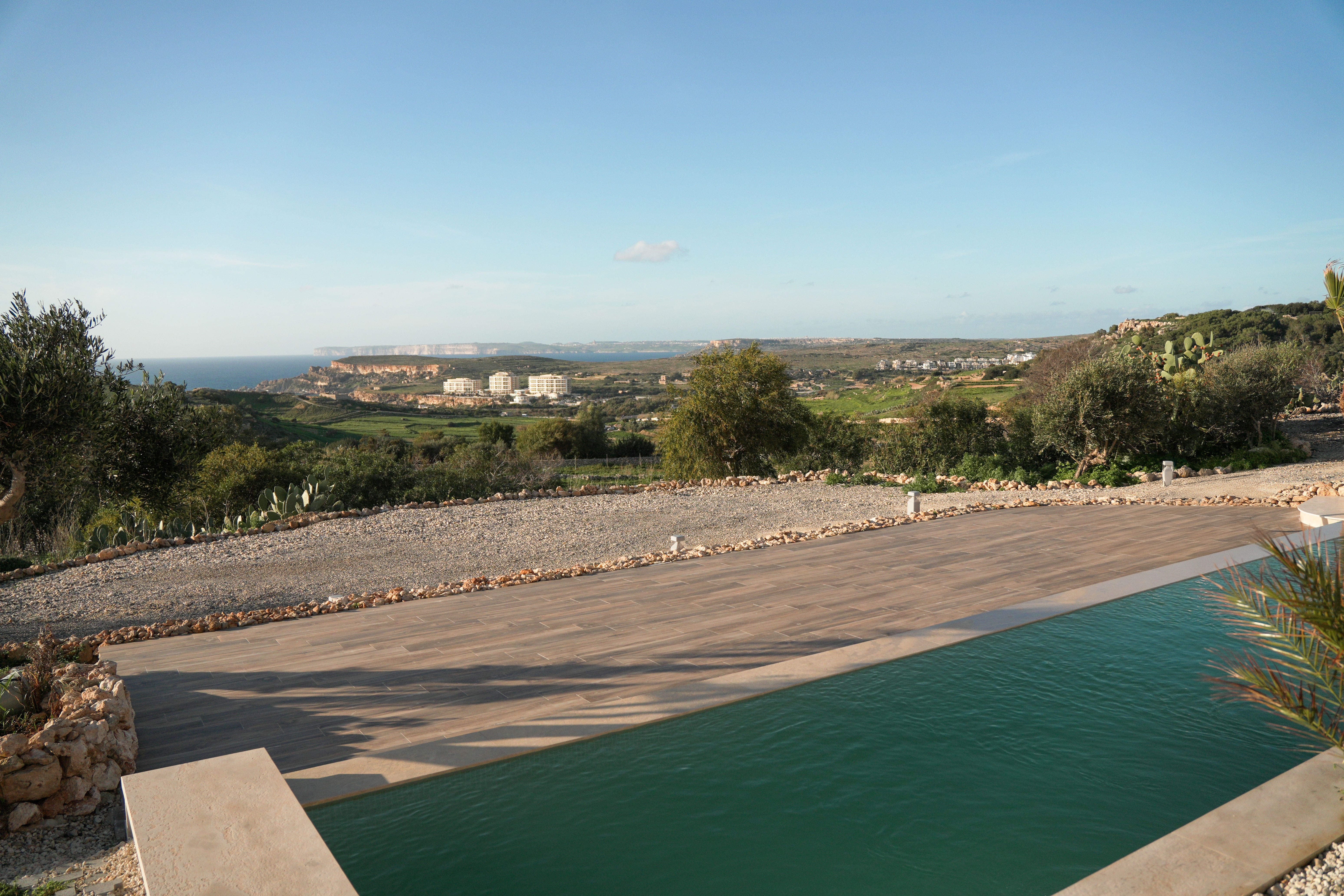A serene spa setting with two lounge chairs beside a warm, reflective pool and soft, natural lighting.