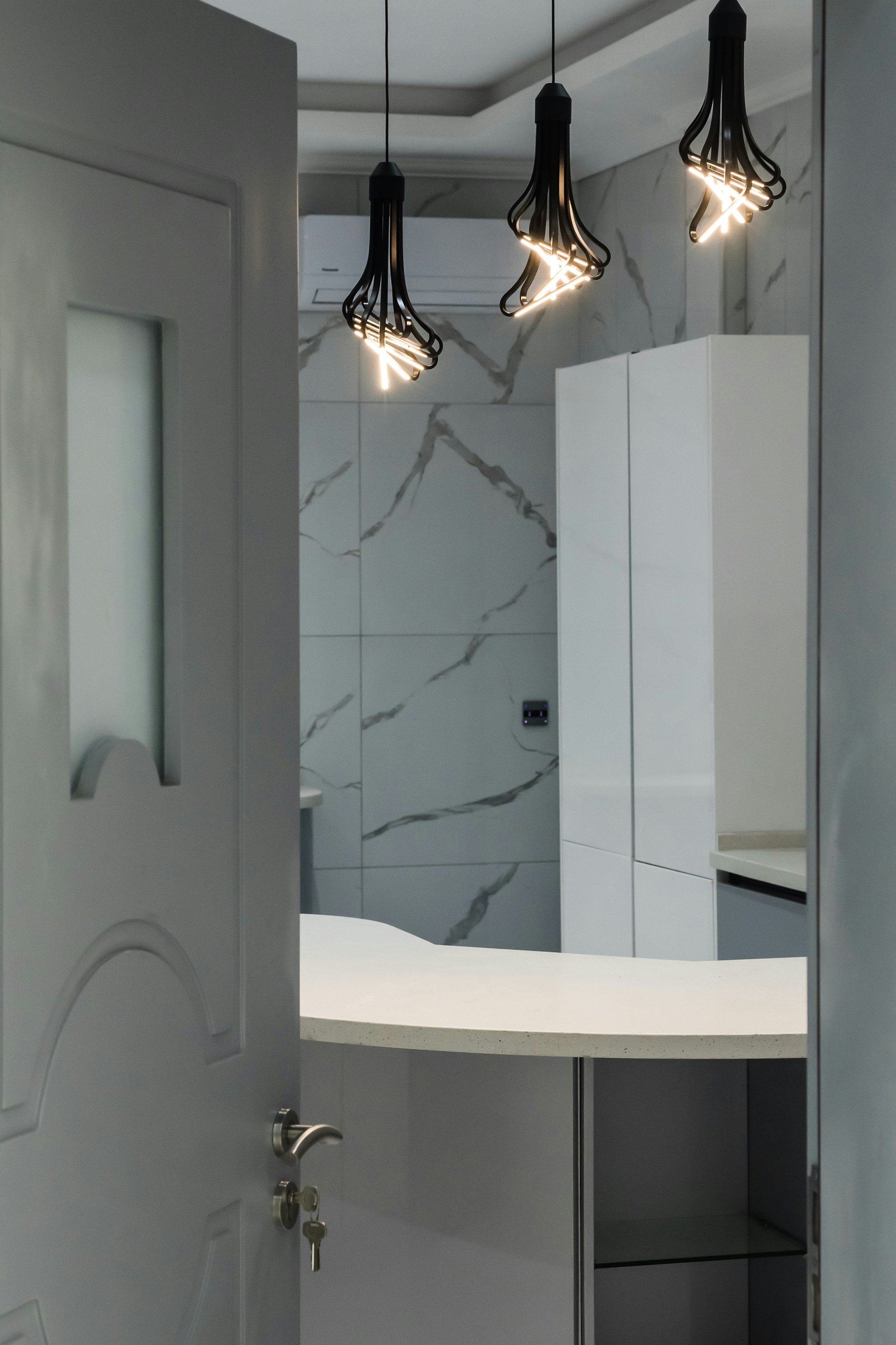 Modern bathroom with a marble wall and sleek fixtures.