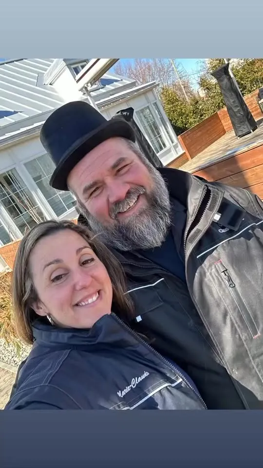 Portrait extérieur des propriétaires du Garage Claude Coutu souriant devant leur maison  Souhaites-tu que je t’aide à organiser toutes ces images en grille cohérente pour le footer ou en bloc
