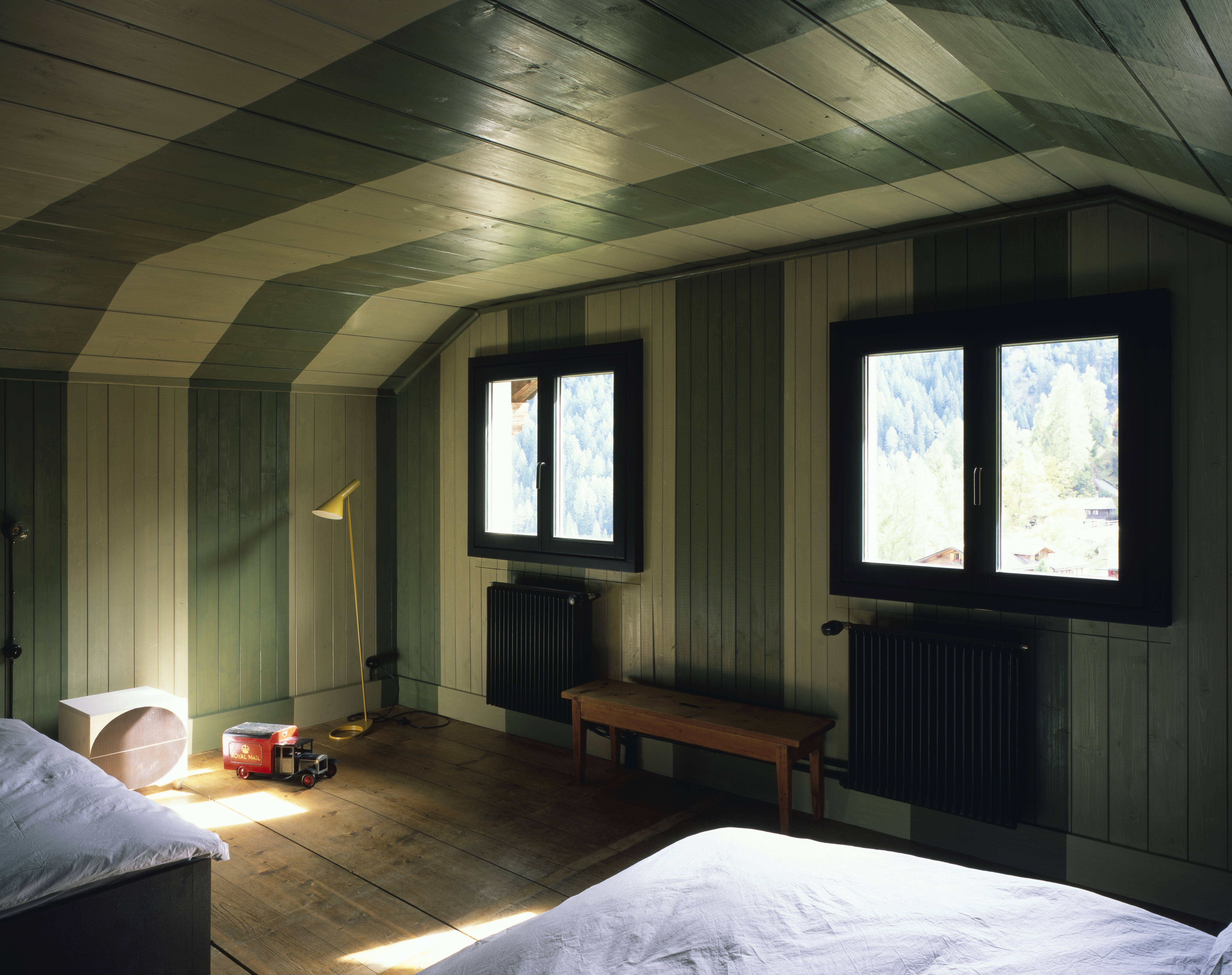 Light and dark green striped bedroom with two windows.