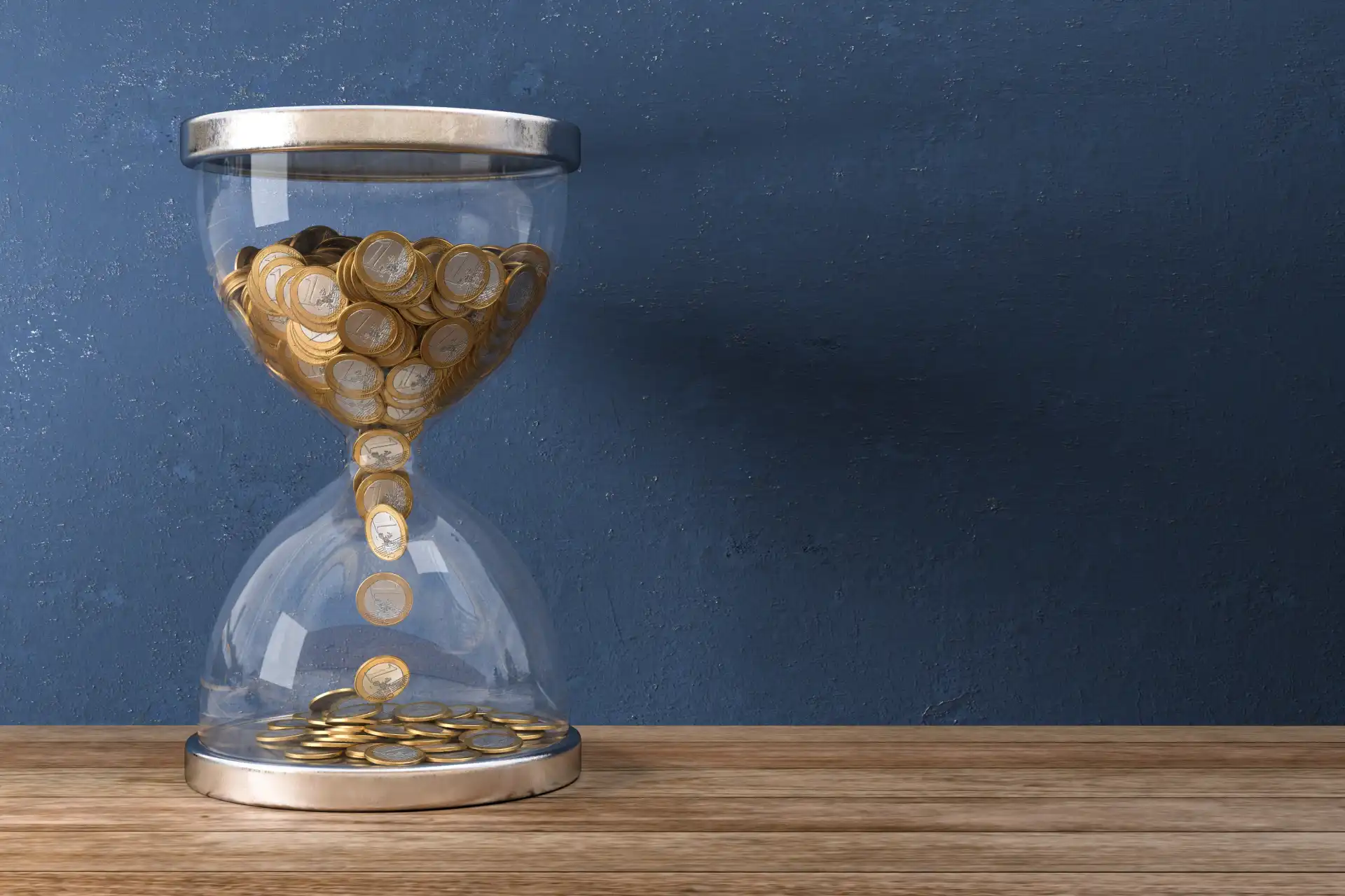 Een zandloper staat op een houten oppervlak, terwijl gouden zand door zijn glazen lichaam stroomt tegen een blauwe achtergrond.