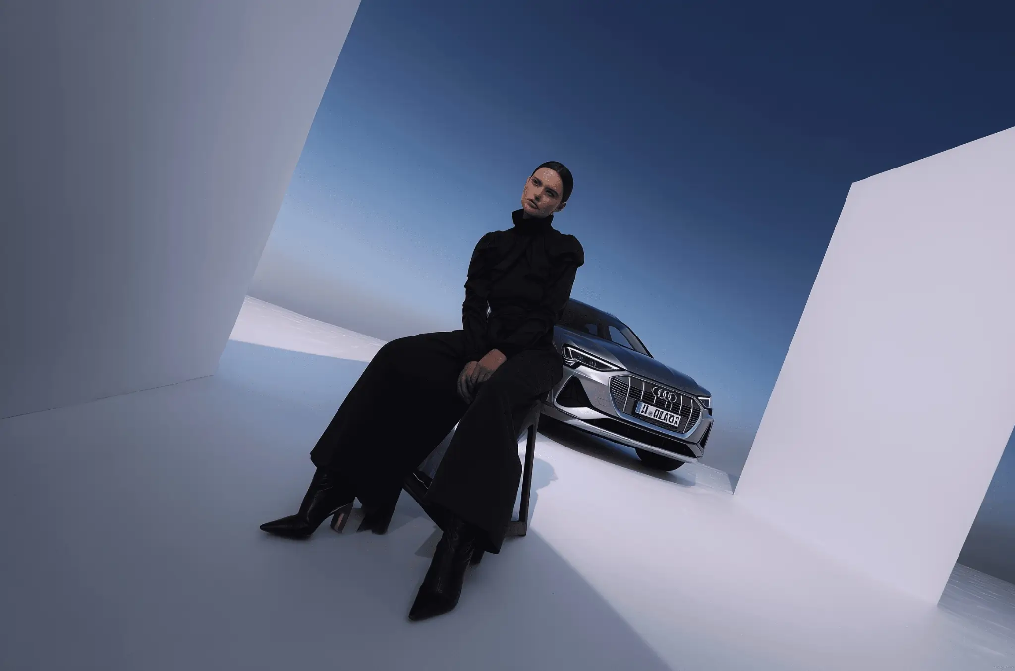 Eine Dame sitzt auf einem Hocker in einem Studio mit blauem Dach und im Hintergrund ein Fahrzeug