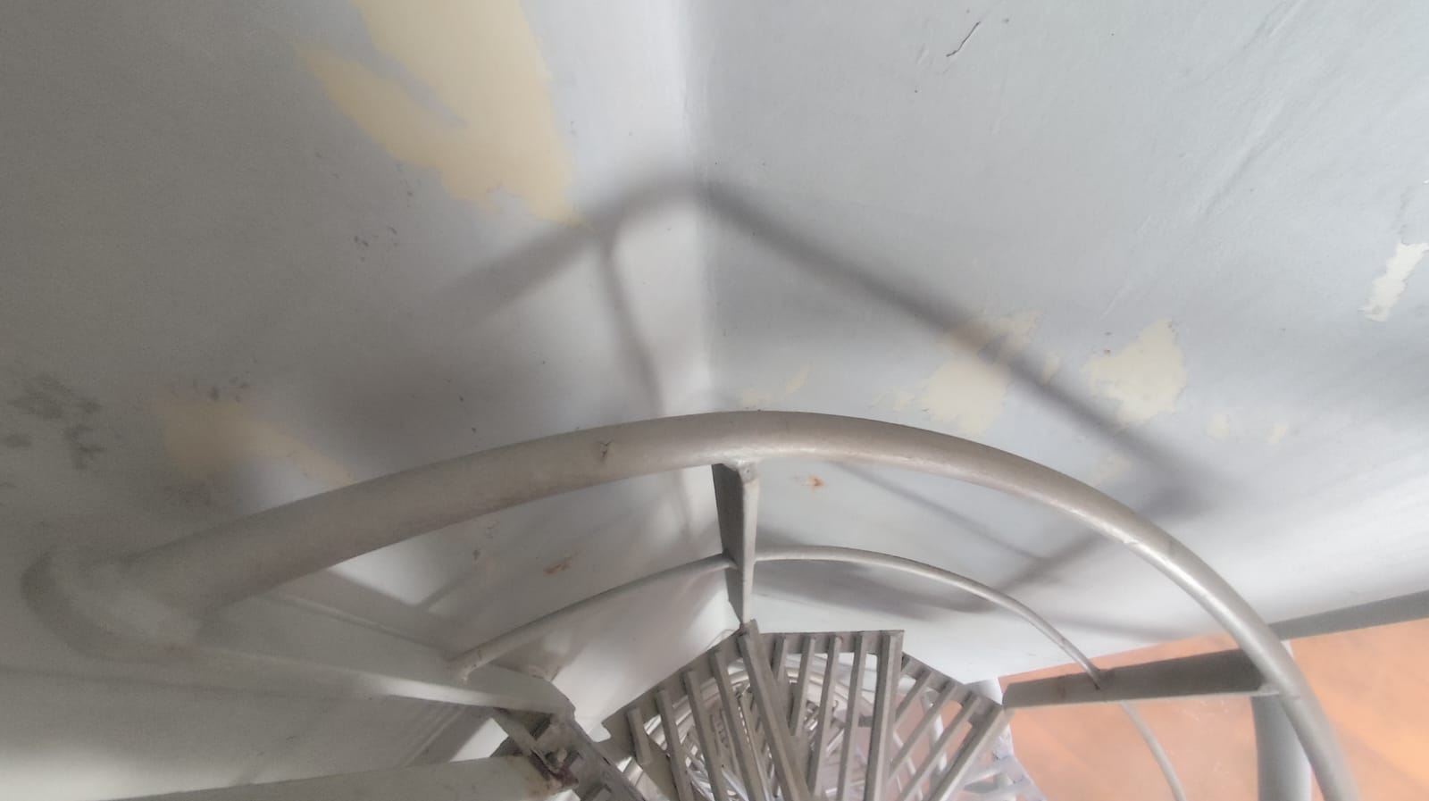 Post-cleaning view of cargo hold access platform and curved handrail, showing painted surfaces after coal cargo cleanup.