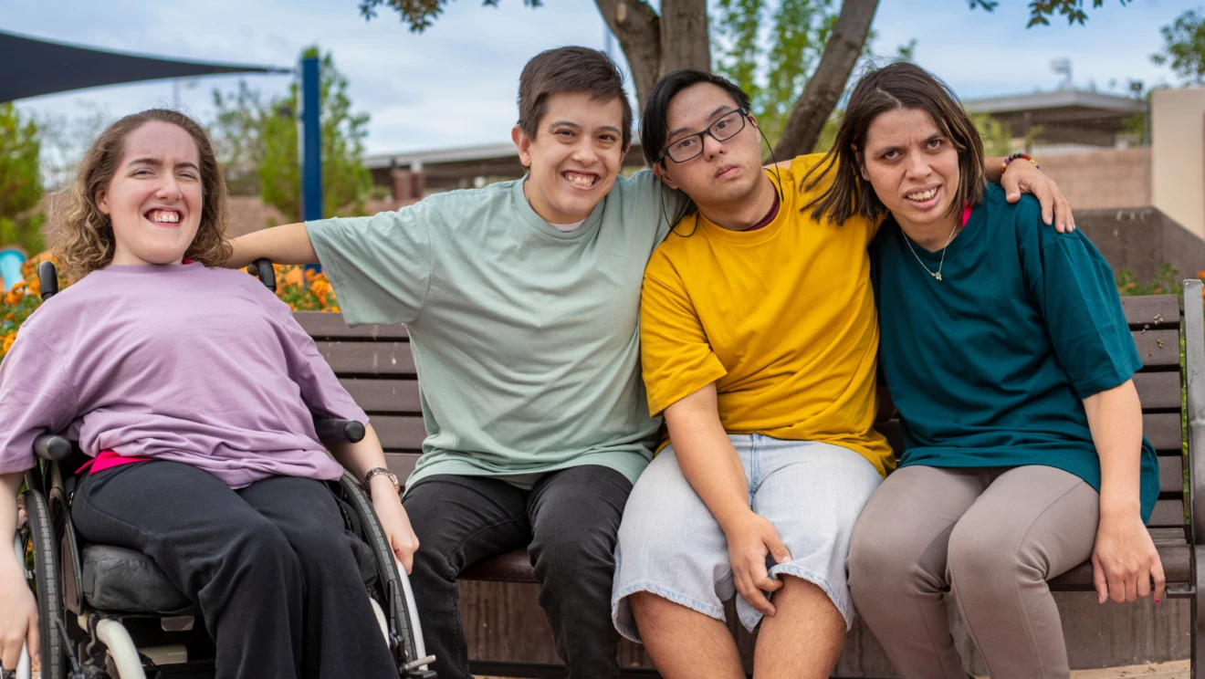 Four young adults with disabilities seated next to each other