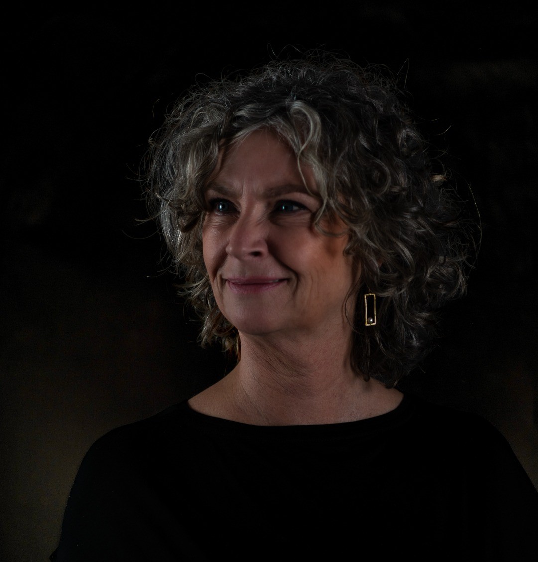 A women with a black shirt, and a dark background