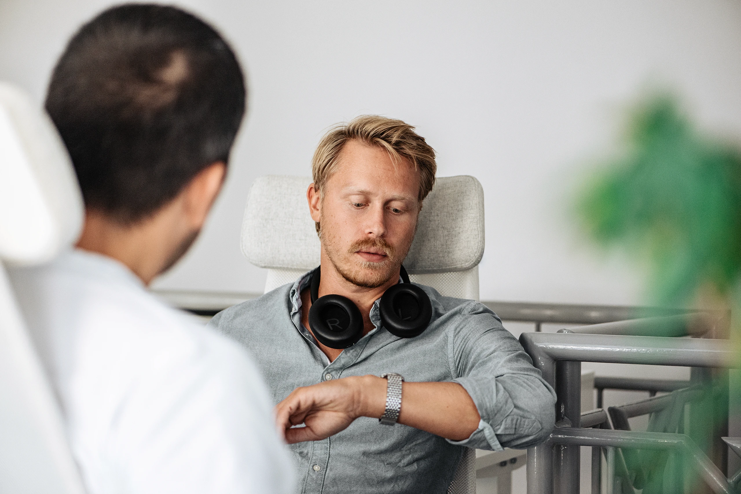 Auxality employee checking the time during a focused moment at work in a modern office.