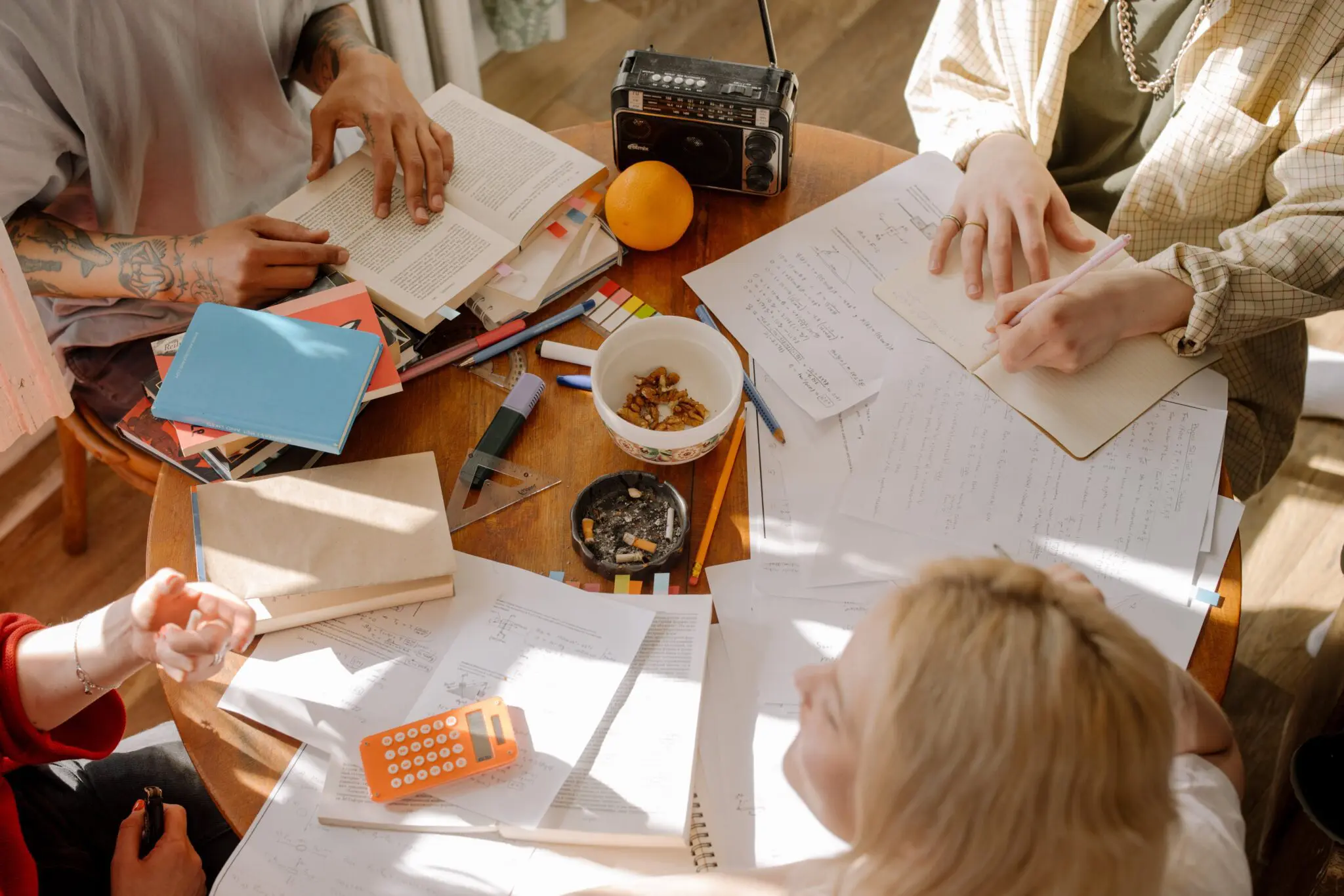Students gathered on a table, doing note revisions