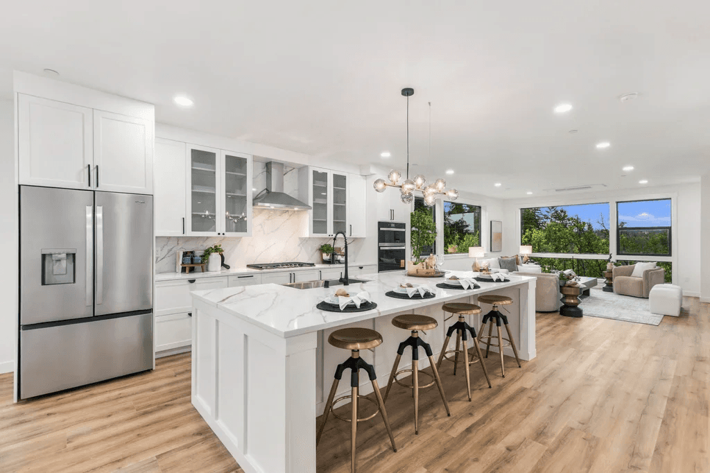 Duchess Townhomes kitchen with a large white quartz island, bar stools and glass pendant lights