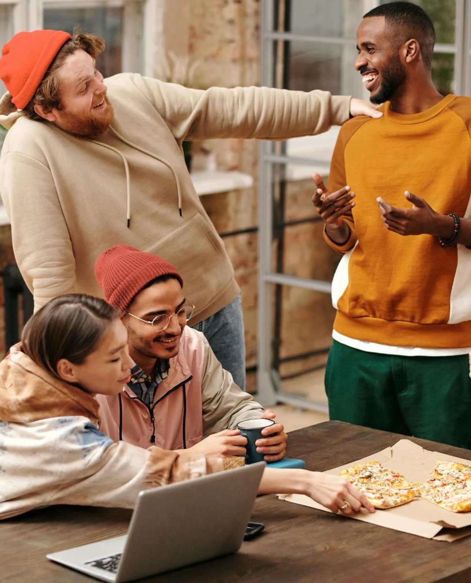 Friends gathered around a table sharing pizza and conversation.