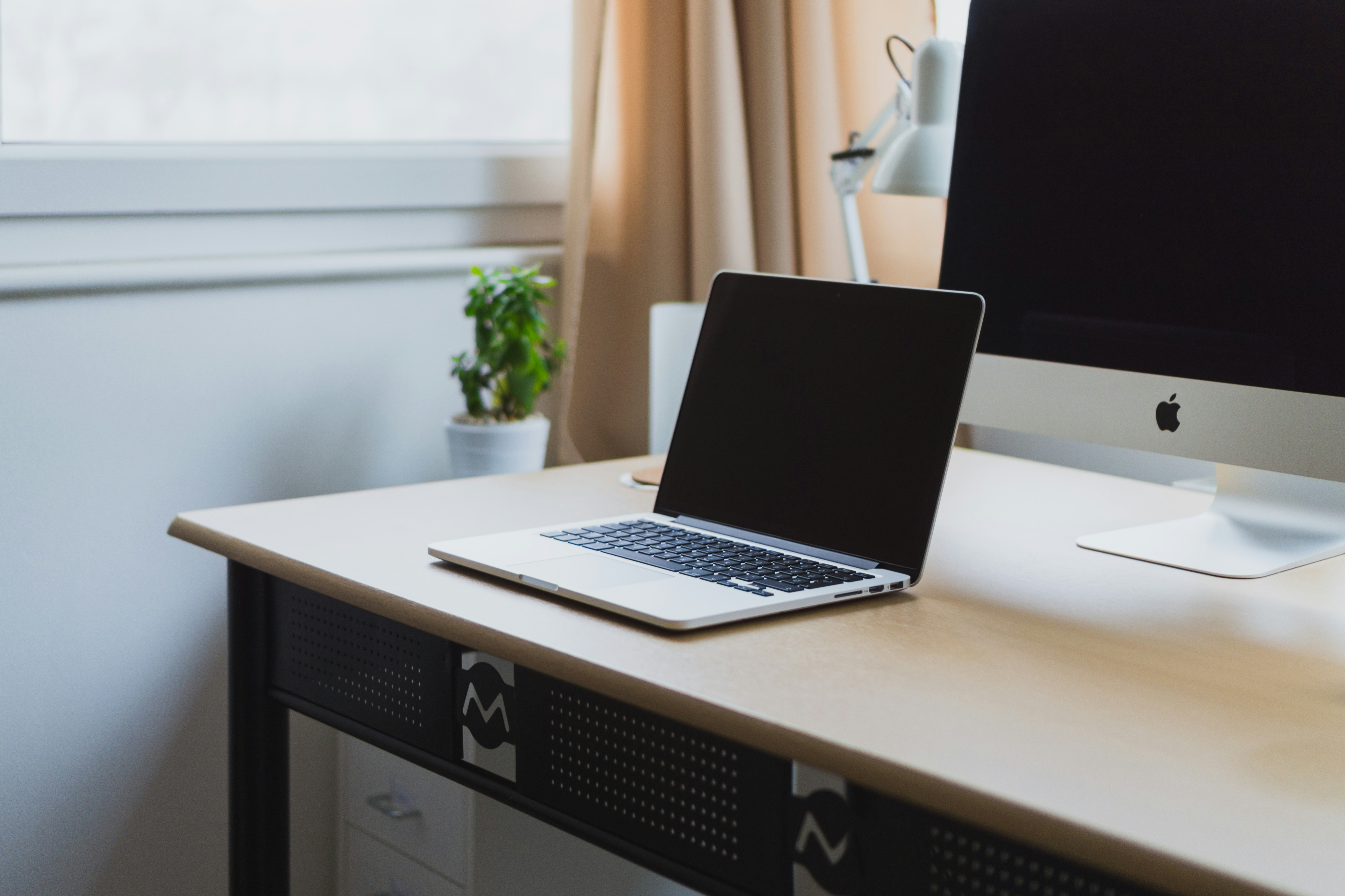 A picture of a laptop sitting in front of a desktop on a desk